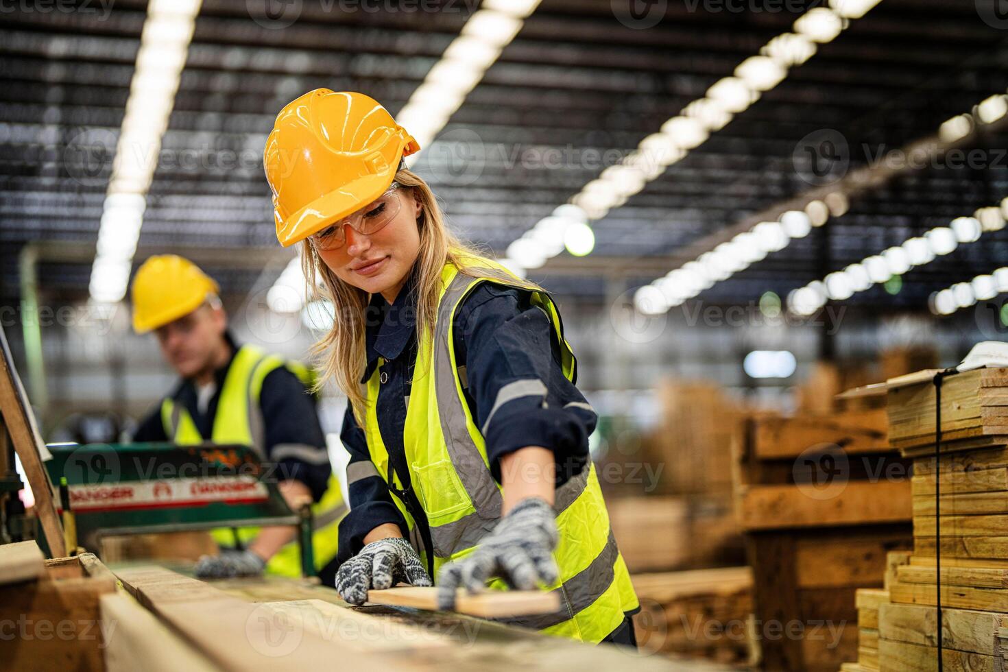 femme nettoyage Charpente bois dans foncé entrepôt industrie. équipe ouvrier Charpentier portant sécurité uniforme et difficile chapeau travail et vérification le qualité de en bois des produits à atelier fabrication. photo