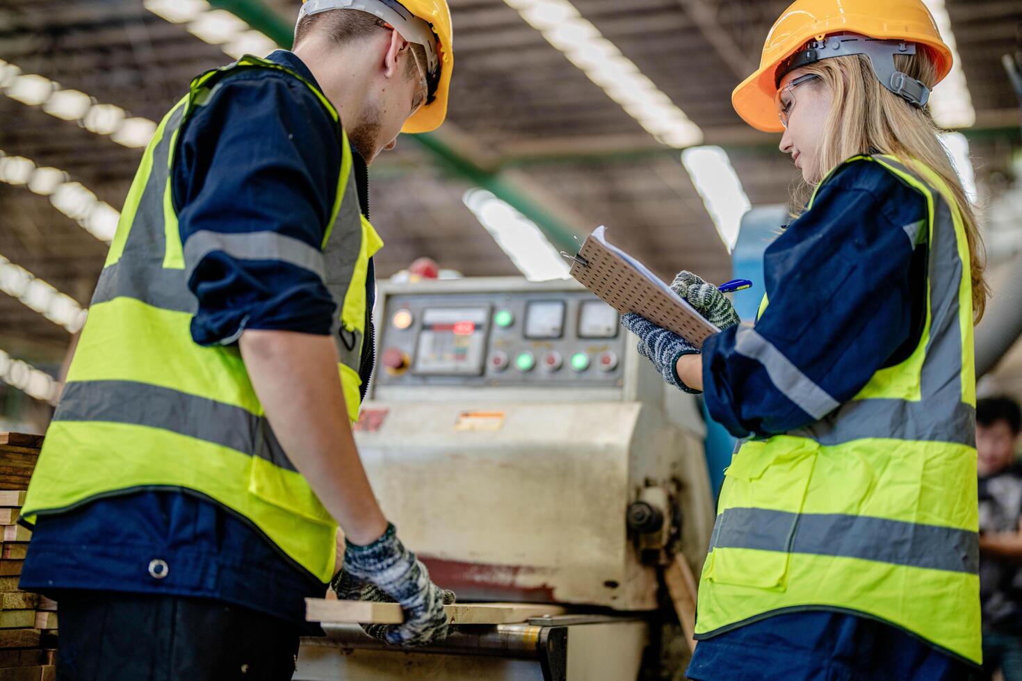 ouvrier charpentiers travail dans Machines à Couper bois Charpente. homme et femme sont artisanat avec bois dans une atelier. deux artisans ou bricoleurs travail avec Charpentier outils ou électrique Machines. photo