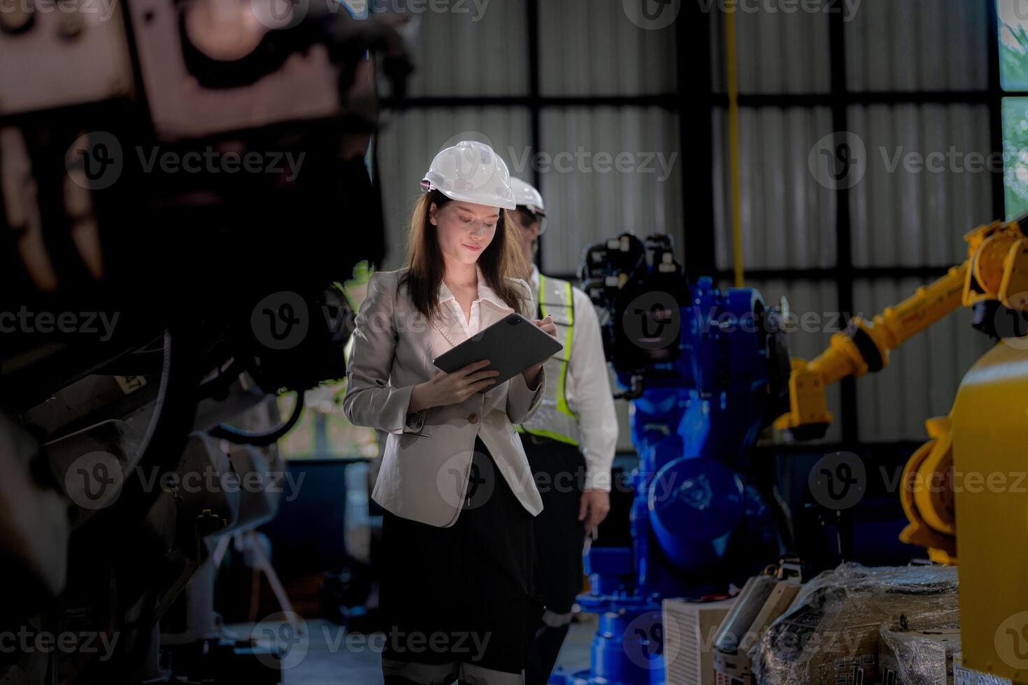 affaires femme et homme réunion et vérification Nouveau machine robot. ingénieur en marchant à entrepôt industrie machine. affaires négociation concepts et technologie. femme est en utilisant intelligent tablette à présent homme. photo