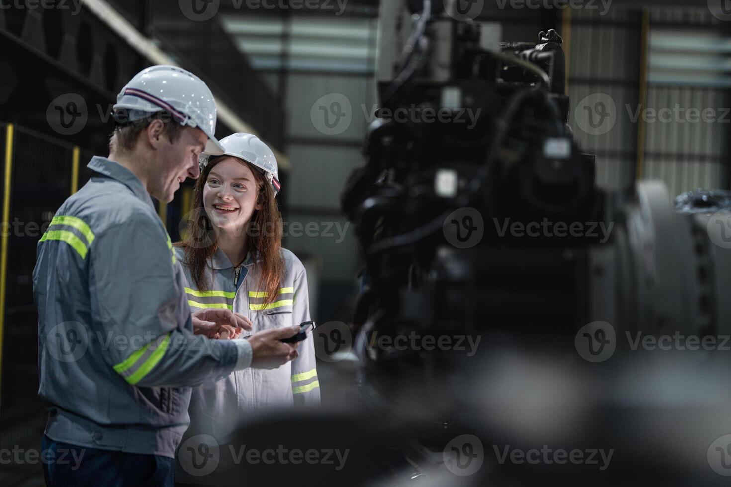 ingénieurs vérifier contrôle lourd machine robot bras. diverse équipe de industriel la robotique ingénieurs recueillies autour machine. professionnel machinerie les opérateurs réparation électrique robot sur brillant numérique panneau. photo