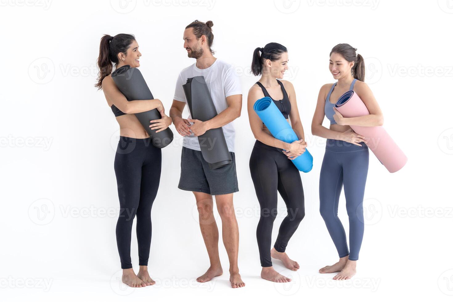 groupe de content sportif les filles et gars portant corps élégant tenue de sport en portant personnel les tapis penché sur une blanc Contexte. attendre pour yoga classe ou corps poids classe. en bonne santé mode de vie et bien-être photo