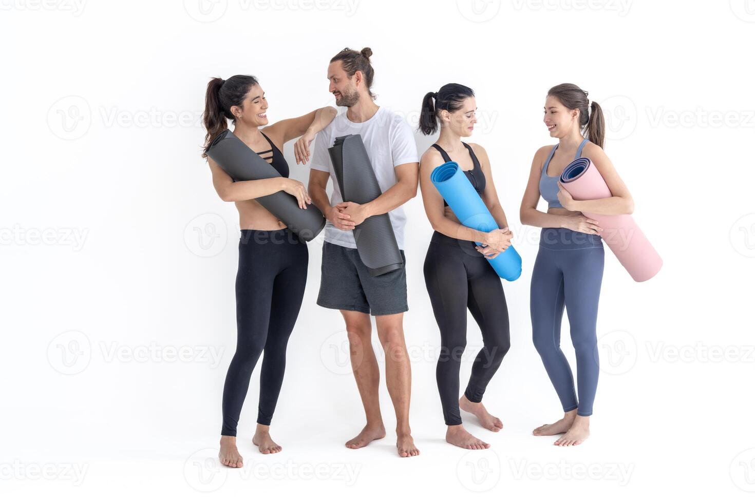 groupe de content sportif les filles et gars portant corps élégant tenue de sport en portant personnel les tapis penché sur une blanc Contexte. attendre pour yoga classe ou corps poids classe. en bonne santé mode de vie et bien-être photo