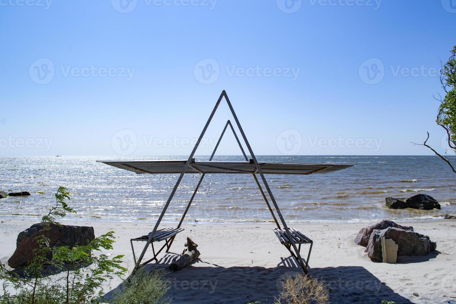 une tonnelle avec bancs sur le plage. magnifique paysage marin. le endroit pour repos. photo