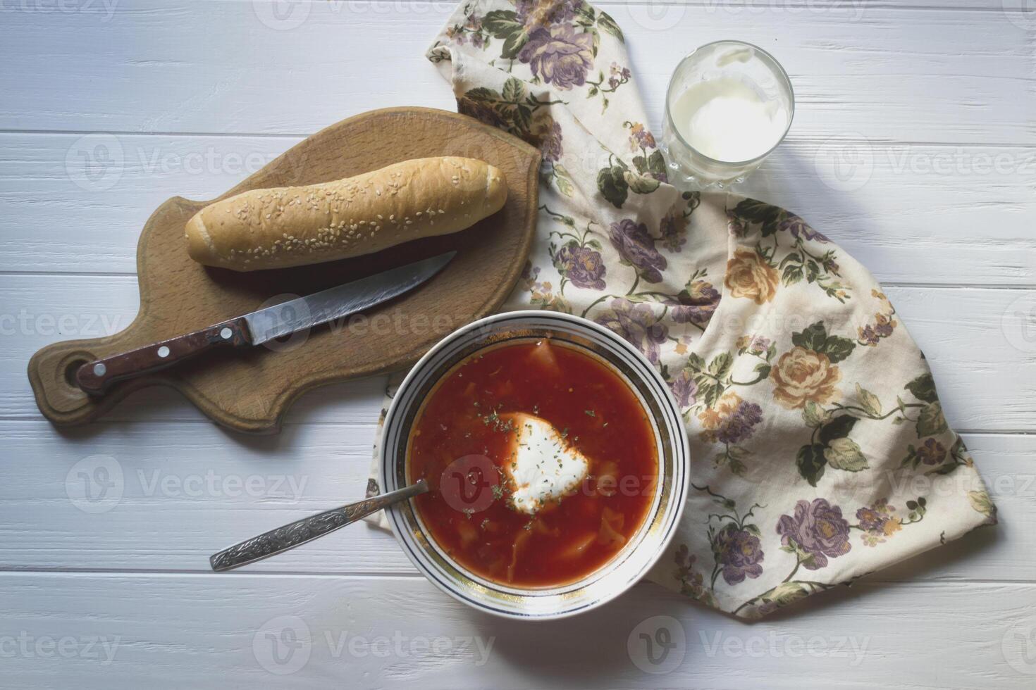 rouge soupe, pain et acide crème sur une blanc en bois tableau. Bortsch - une traditionnel plat de russe cuisine. photo