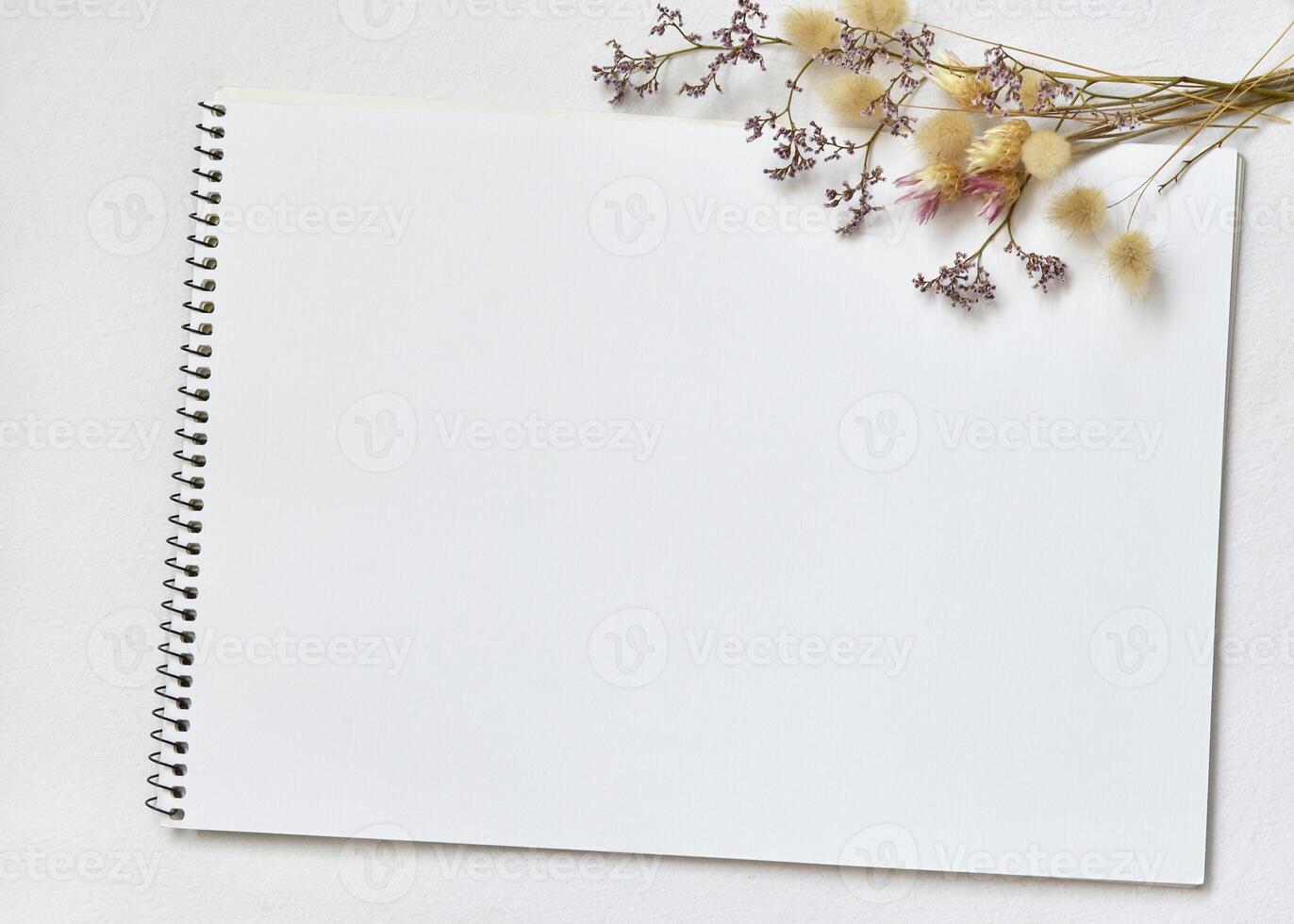 blanc aquarelle carnet de croquis sur lin nappe de table avec brins de lagurus et séché fleurs photo