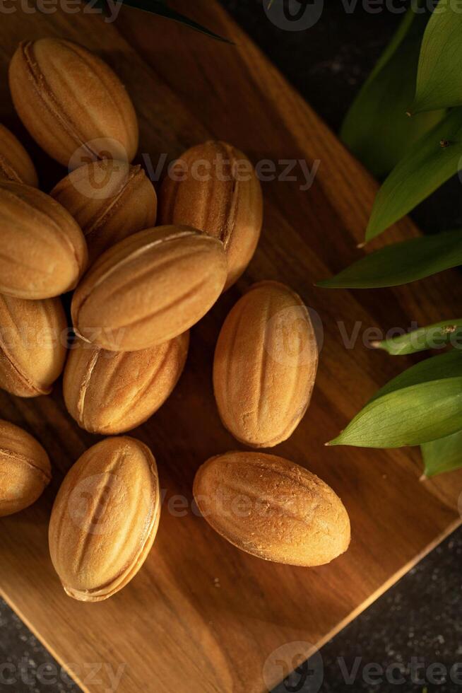 pile de amande des noisettes dans en bois bol sur foncé Contexte photo