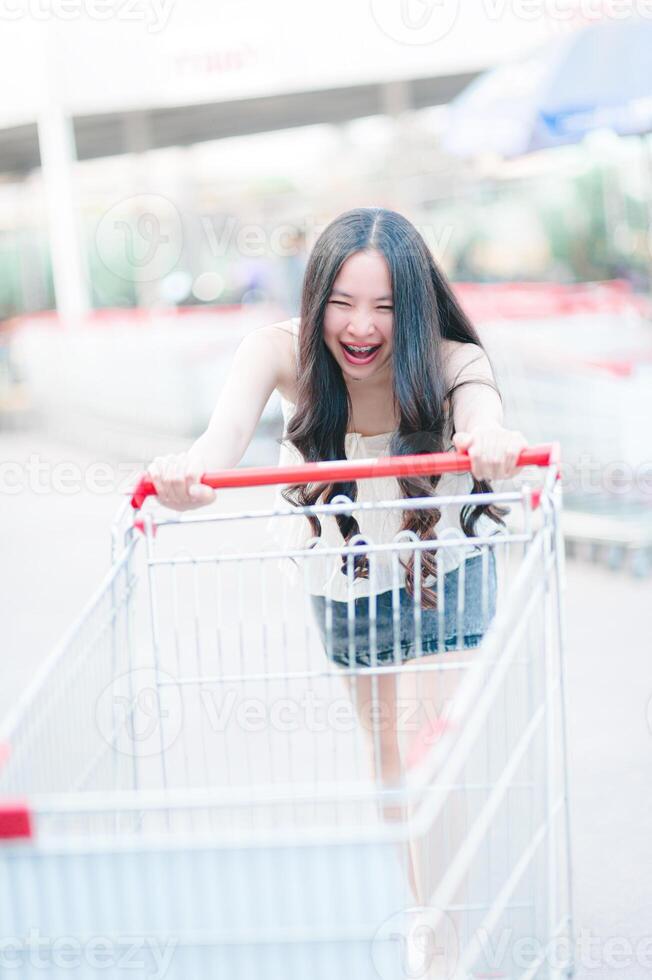 asiatique femme pousser achats Chariot dans achats centre commercial photo