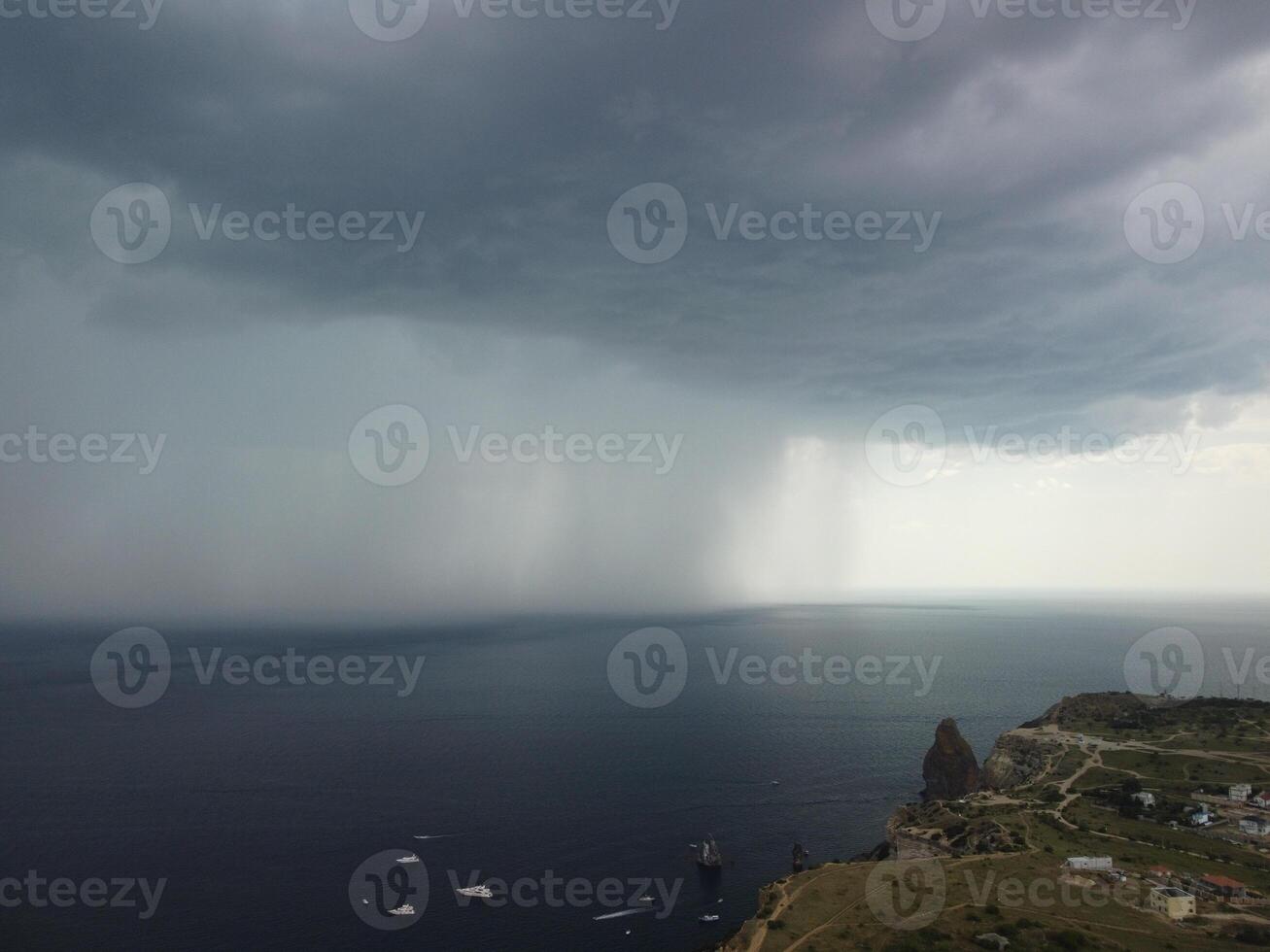 aérien vue métrage de pluie des nuages plus de mer océan noir des nuages dans mal temps journée plus de mer surface haute angle vue la nature voir. apocalypse. orage grand cargaison foncé sombre pluie des nuages plus de une calme mer. photo