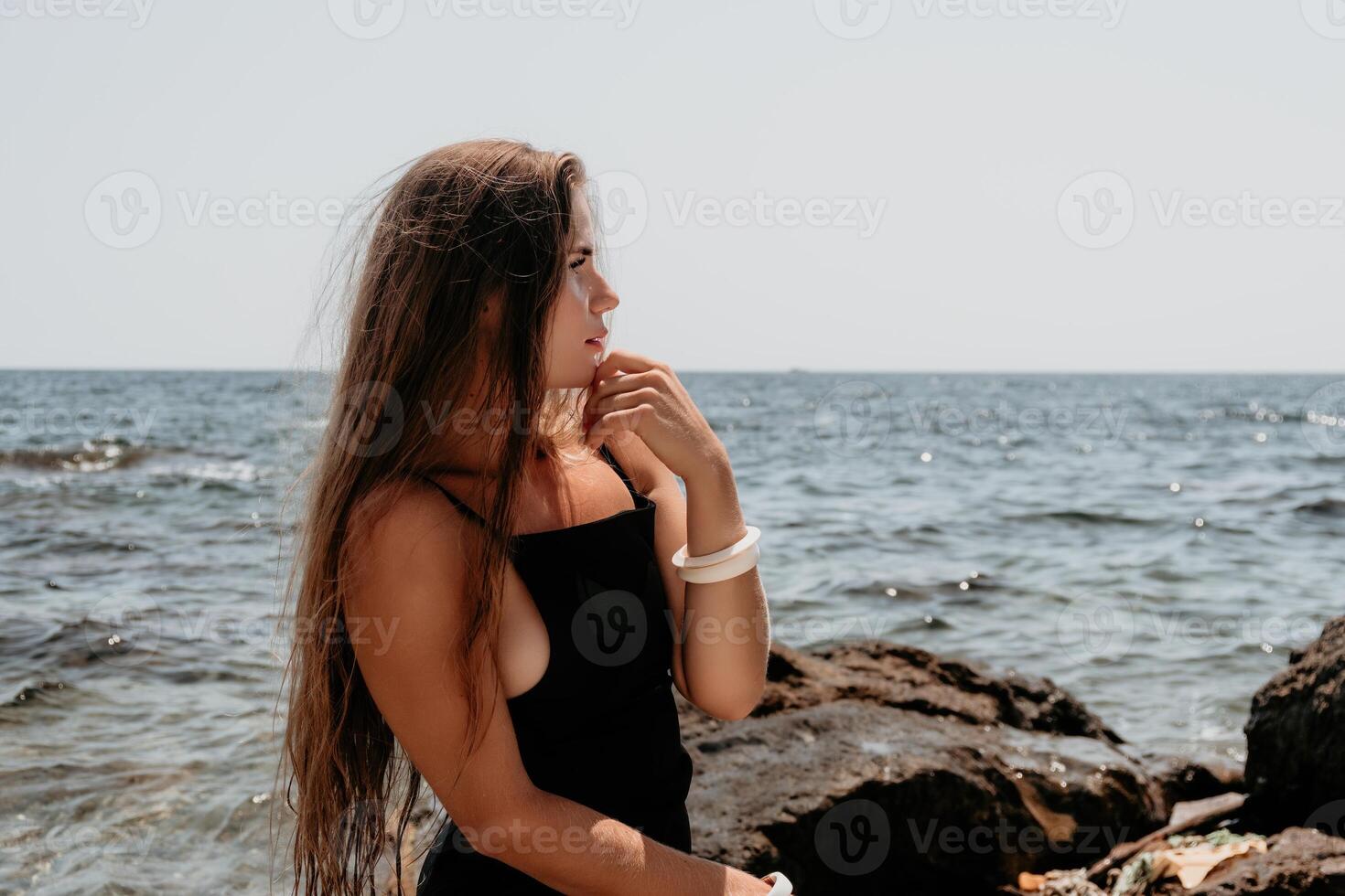 femme été Voyage mer. content touristique dans chapeau prendre plaisir prise image en plein air pour souvenirs. femme voyageur posant sur le plage à mer entouré par volcanique montagnes, partage Voyage aventure périple photo