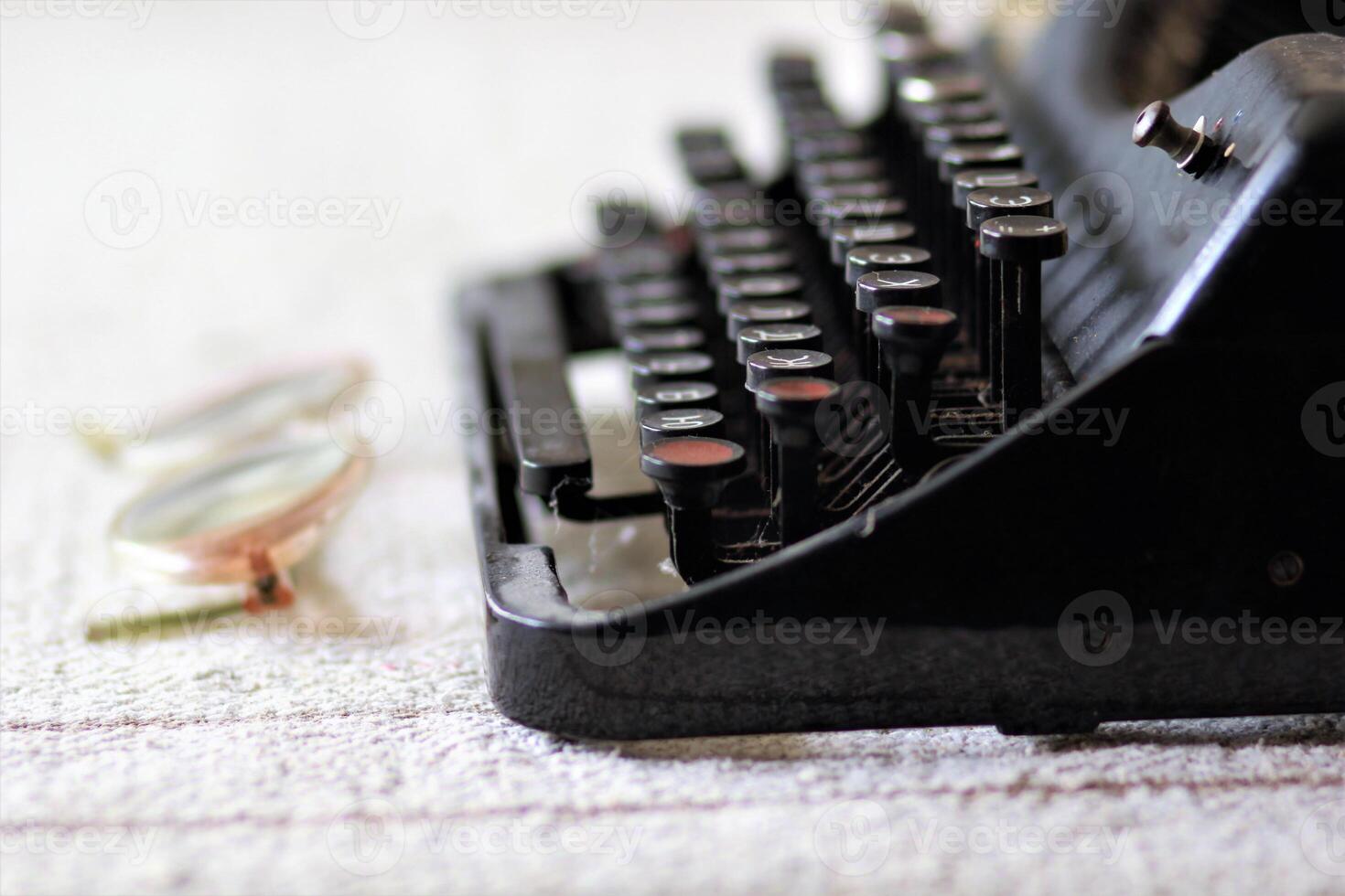 ancien machine à écrire, des lunettes sur lin nappe de table, côté vue proche en haut photo