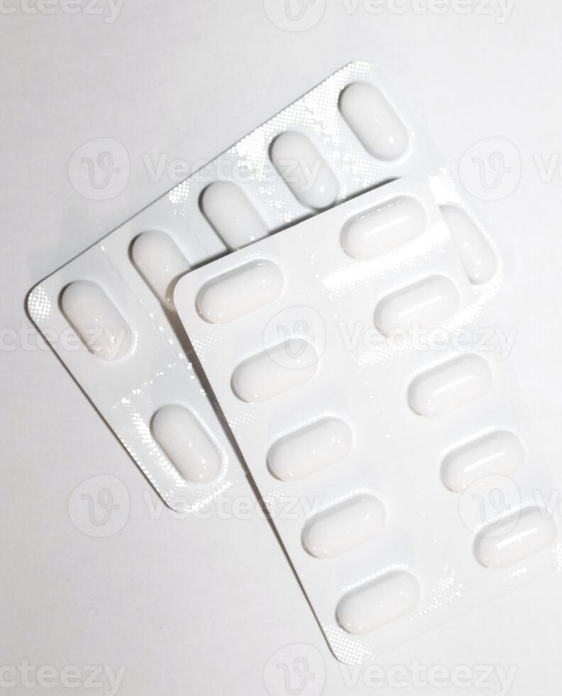 concept de pharmacie pharmacie. packs de pilules blanches emballées dans des blisters avec espace de copie isolé sur fond blanc. se concentrer sur le premier plan, bokeh doux. photo