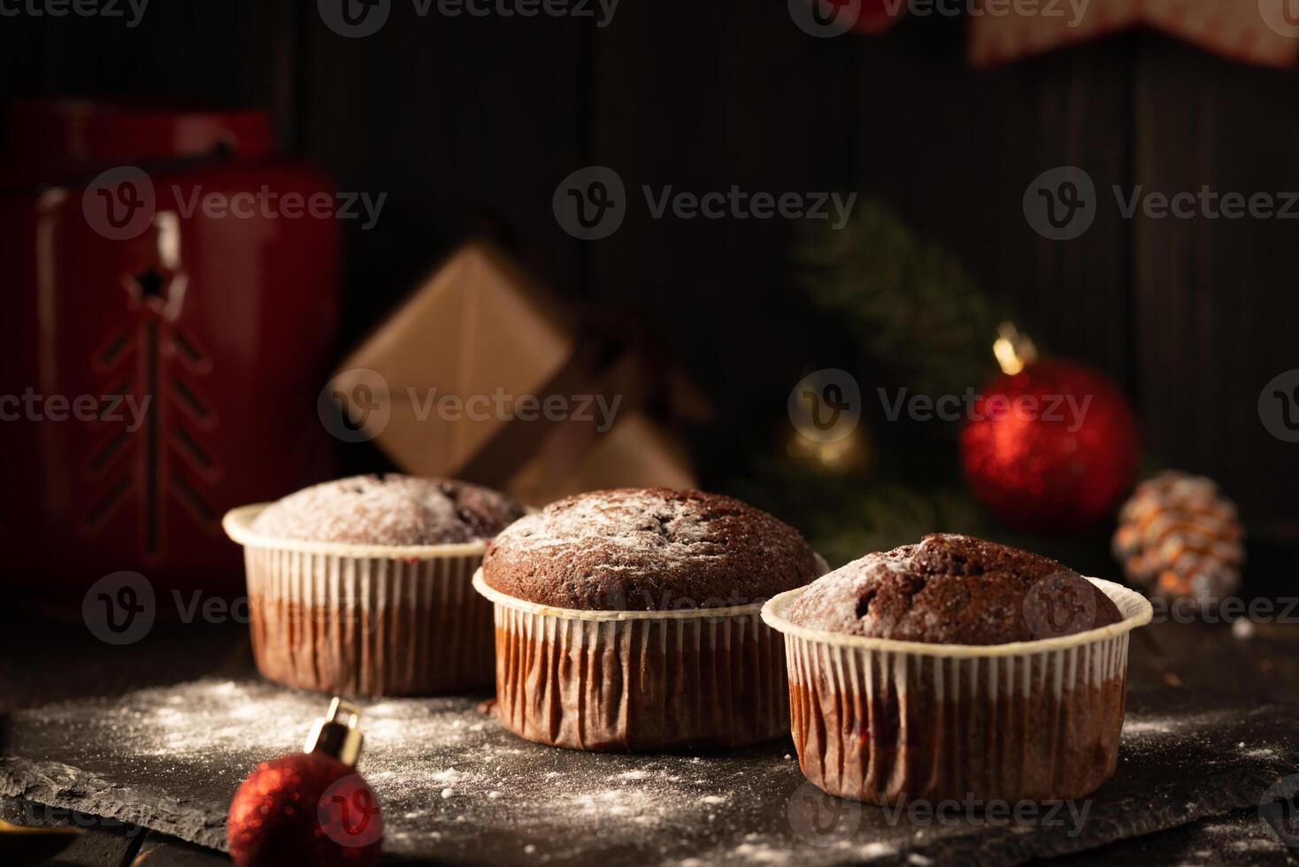 Chocolat muffins avec en poudre sucre sur Haut sur une noir Contexte. Noël décoration . encore la vie proche en haut. nourriture photo. photo