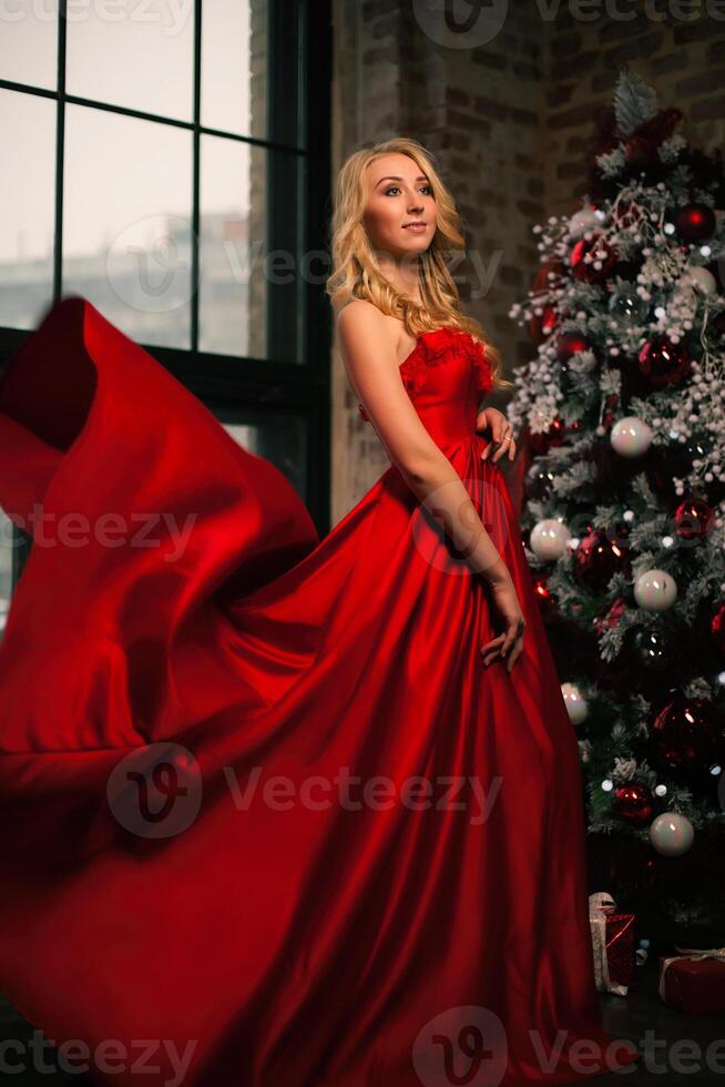 content Nouveau année à vous magnifique Jeune femmes dans une rouge robe fête Noël avec une présente. Nouveau années faire la fête. Noël veille. photo