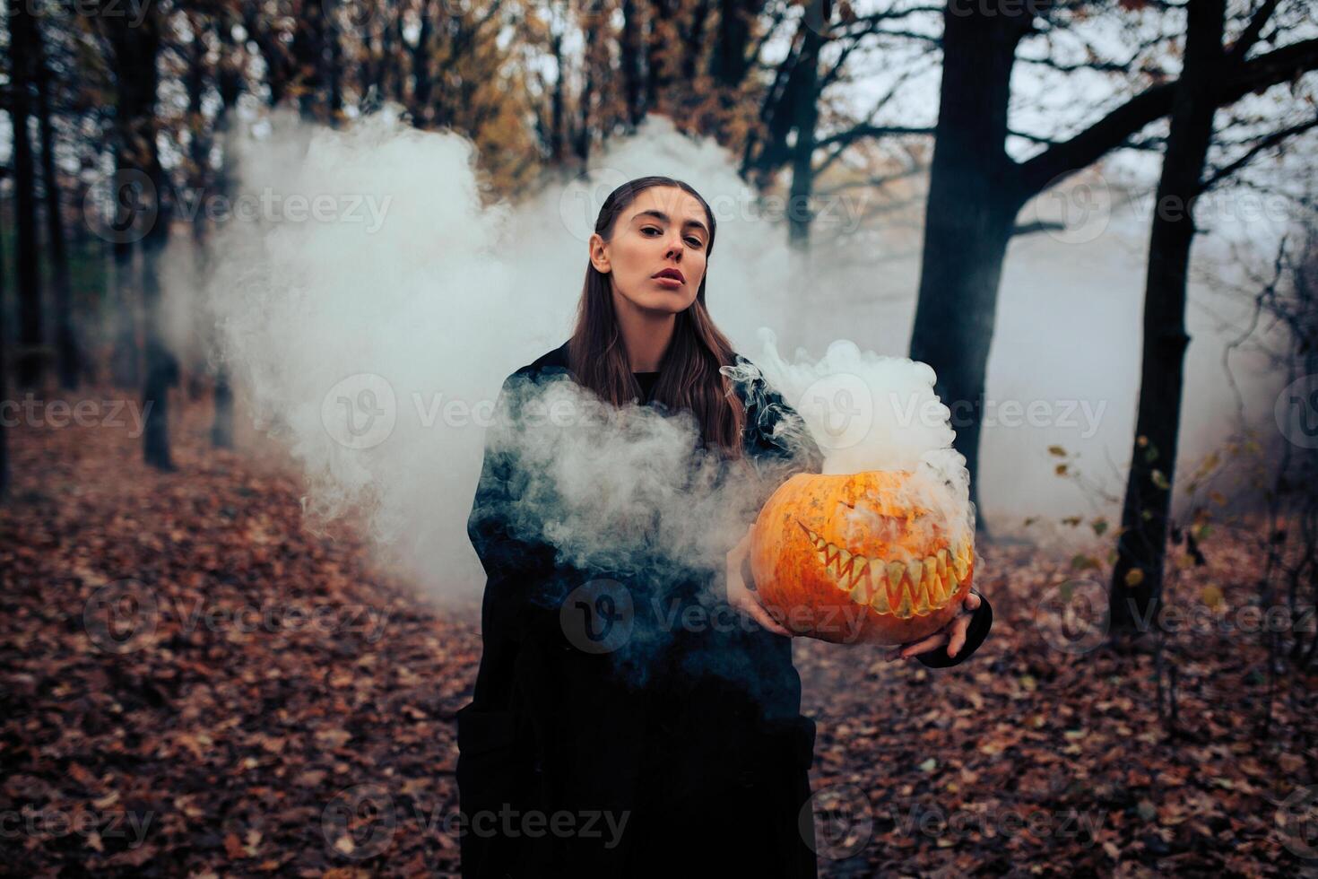 Jeune femme en portant le Halloween citrouille avec le blanc fumée à venir de à l'intérieur de il photo