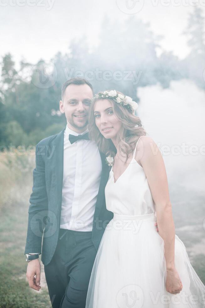 la mariée et jeune marié à mariage journée en marchant en plein air sur été la nature. de mariée couple, content nouveau marié femme et homme embrassement dans vert parc. aimant mariage couple Extérieur. la mariée et jeune marié photo