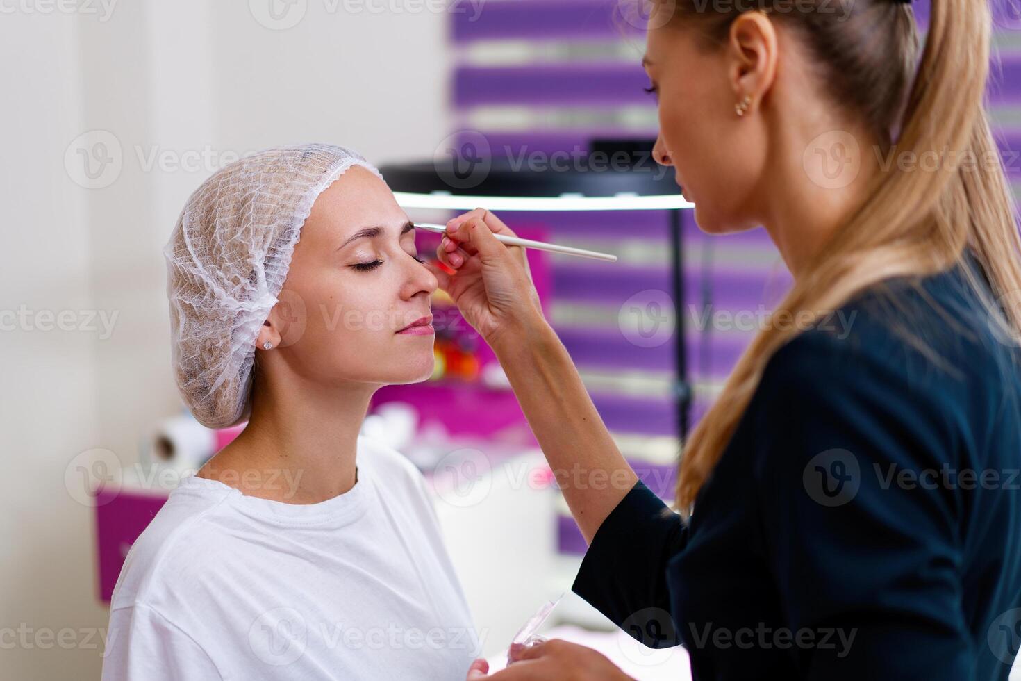 cosmétologie cabinet client séance sur canapé. esthéticien s'applique marquage sur les sourcils. photo