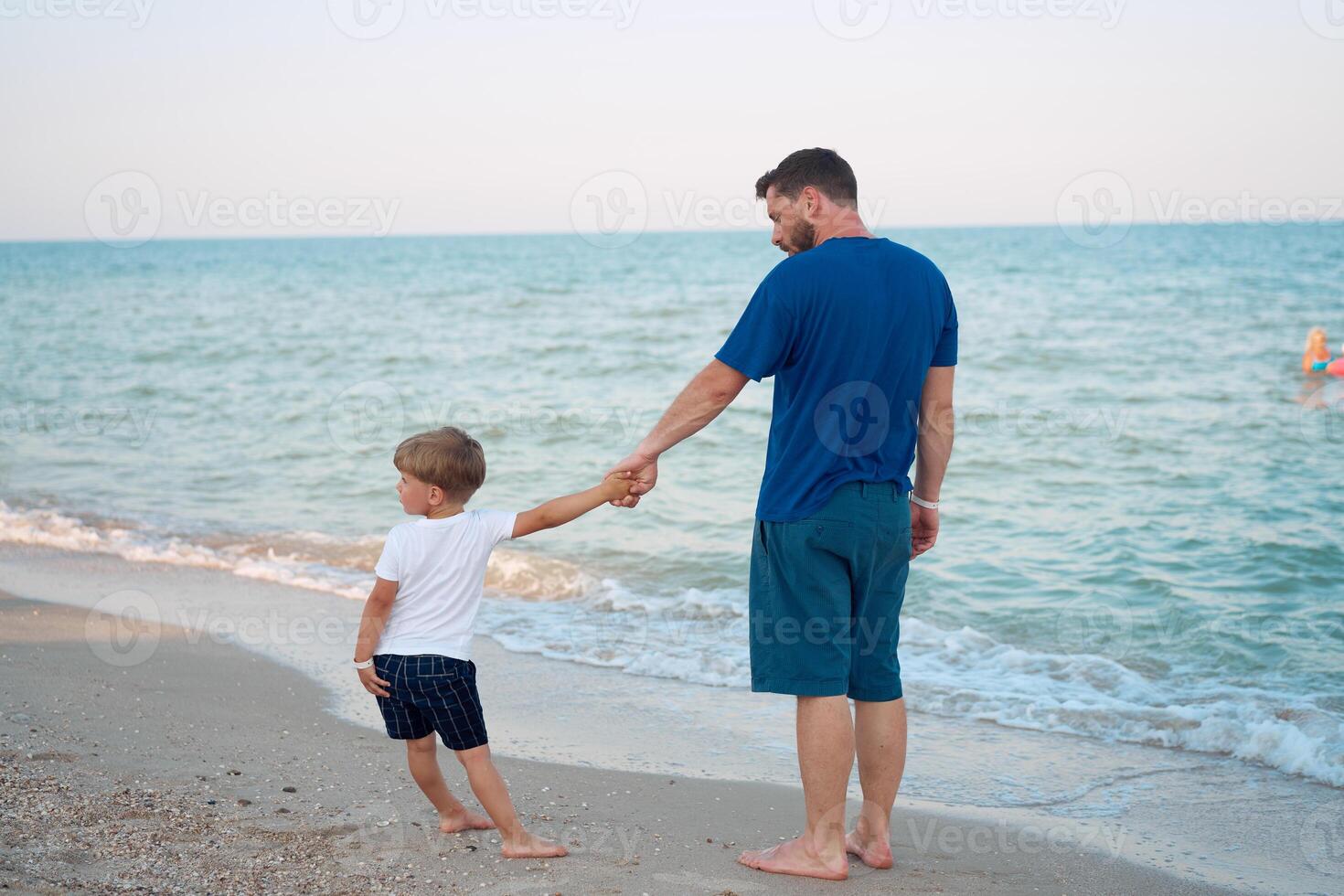 père fils dépenses temps ensemble mer vacances Jeune papa enfant peu garçon en marchant plage photo