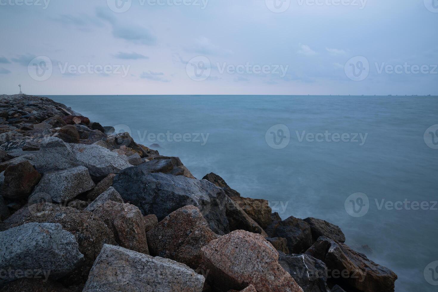 Roche digue dans le mer dans le Matin photo