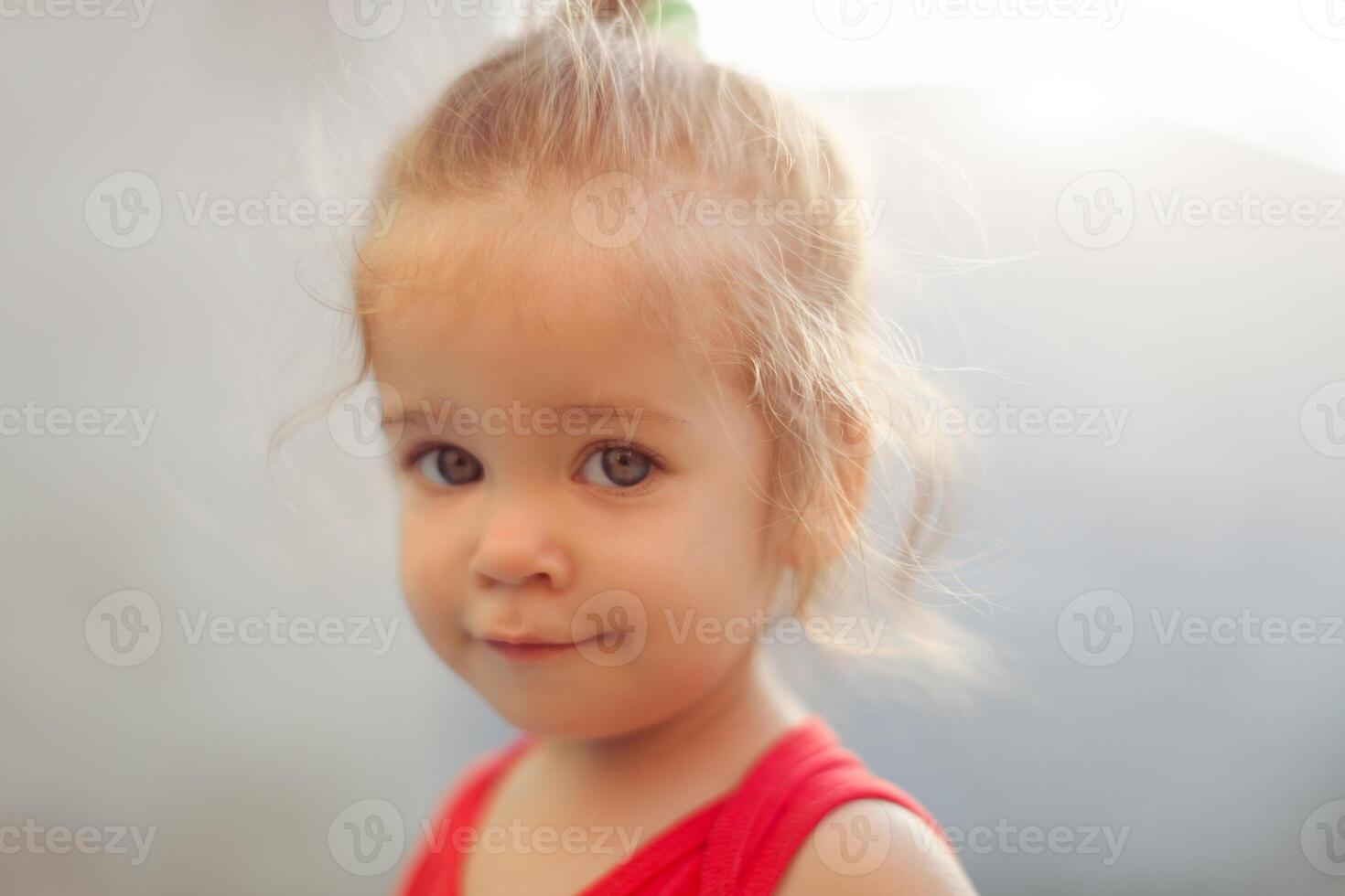 portrait de blond fille avec bleu yeux dans le parc. enfant, bébé fille proche en haut sourire photo