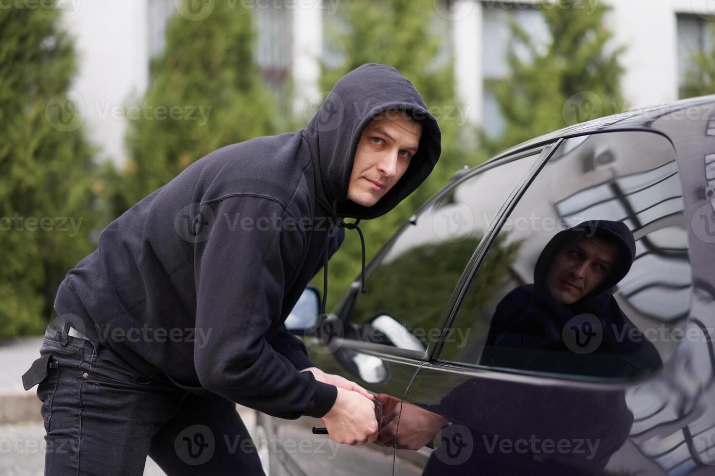 voiture jacking voleur voler voiture rupture porte criminel emploi cambrioleur détournements auto voleur noir cagoule sweat à capuche en essayant Pause dans véhicule Tournevis rue la criminalité la violence bandit voleur voiture photo