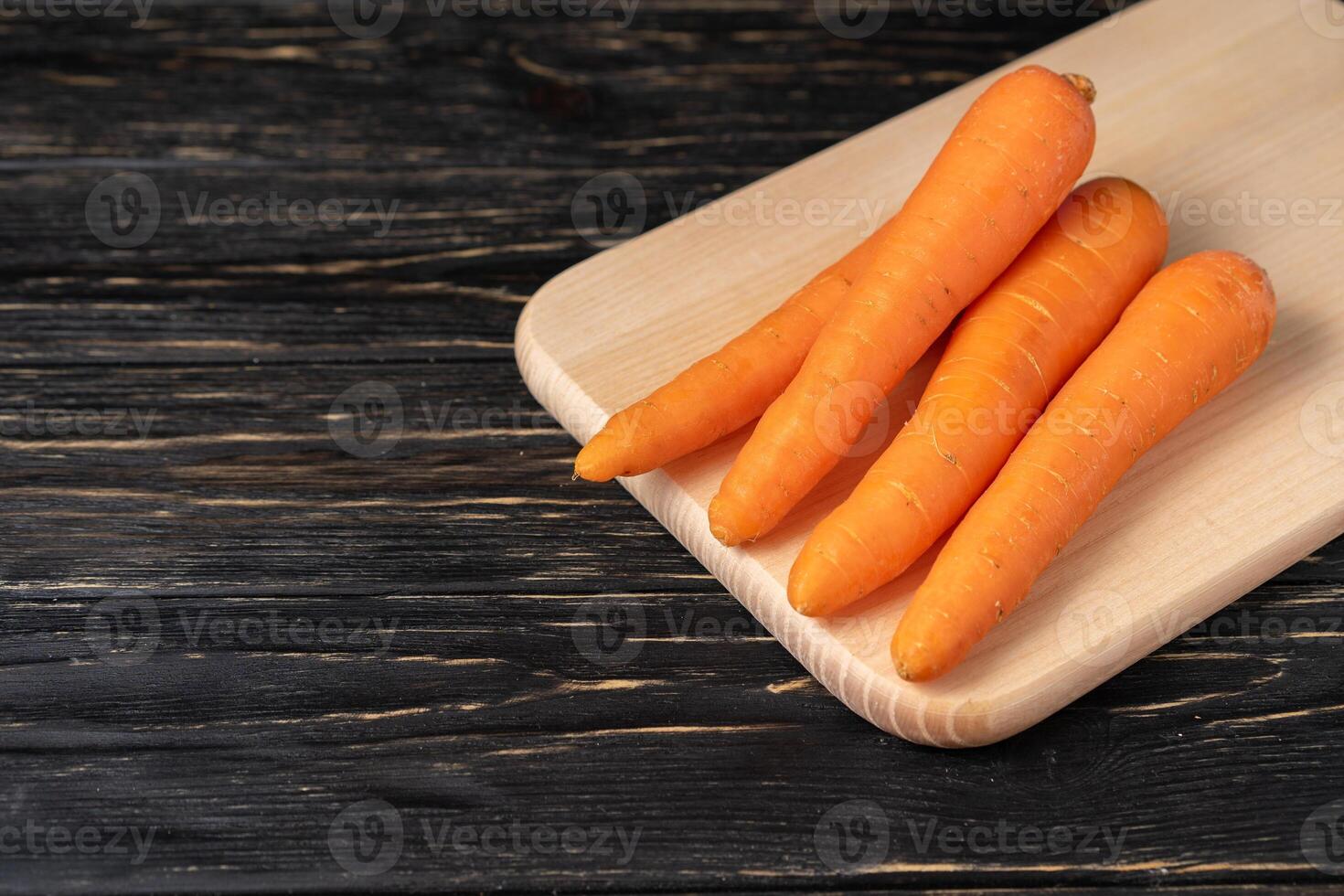 Frais carottes sur couper planche avec noir bois Contexte photo