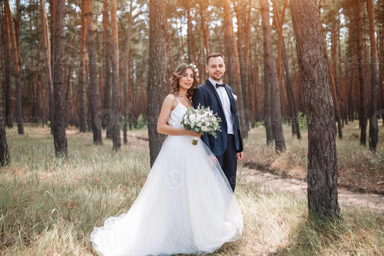 la mariée et jeune marié à mariage journée en marchant en plein air sur été la nature. de mariée couple, content nouveau marié femme et homme embrassement dans vert parc. aimant mariage couple Extérieur. la mariée et jeune marié photo