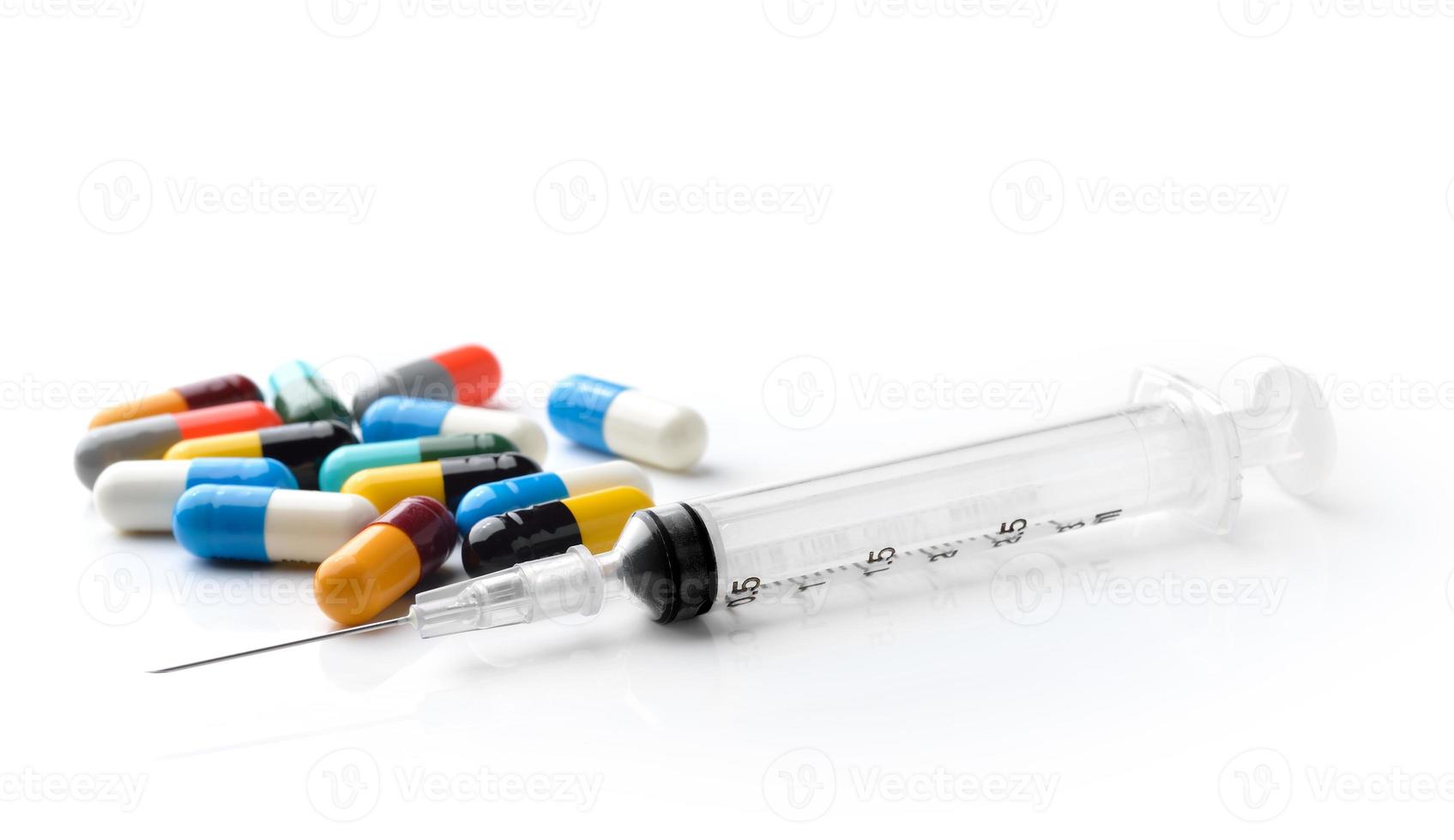 seringue et pilule colorée et capsules sur fond blanc photo
