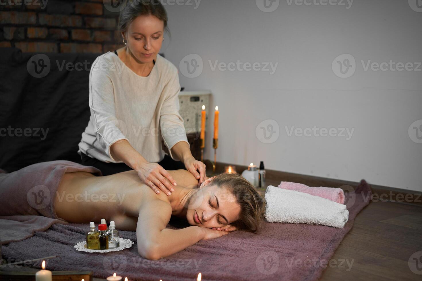 se détendre et prendre plaisir dans spa salon, avoir massage par professionnel masseur. femme mensonge avec nu retour se détendre sur sol couverture photo