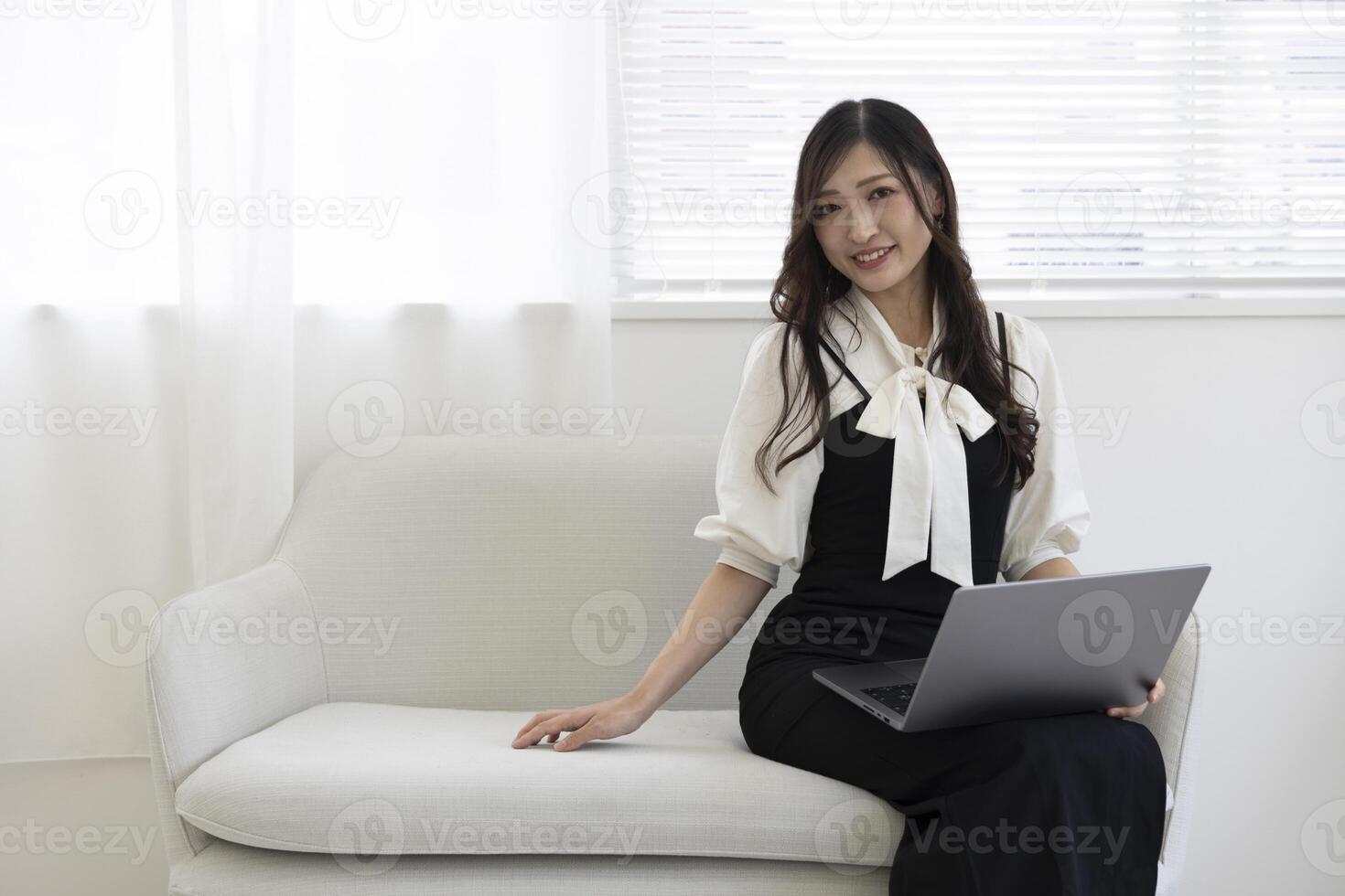 une Japonais femme vérification téléphone intelligent par éloigné travail dans le Accueil Bureau photo