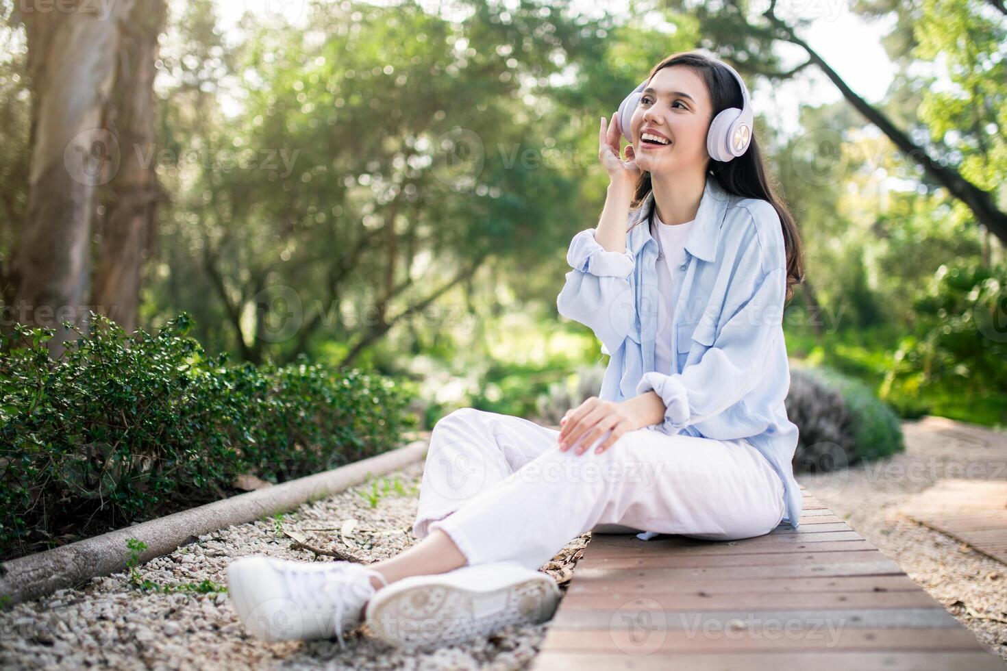Enchanté Jeune femme avec blanc écouteurs à la recherche en haut et souriant photo