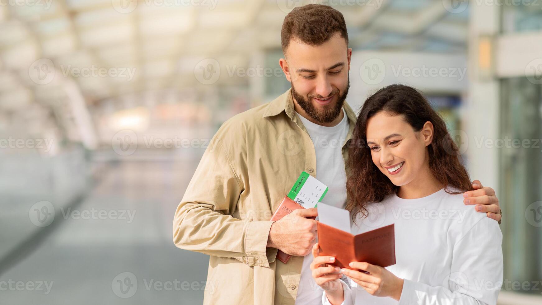 Jeune content couple vérification passeports et des billets tandis que attendre à aéroport photo