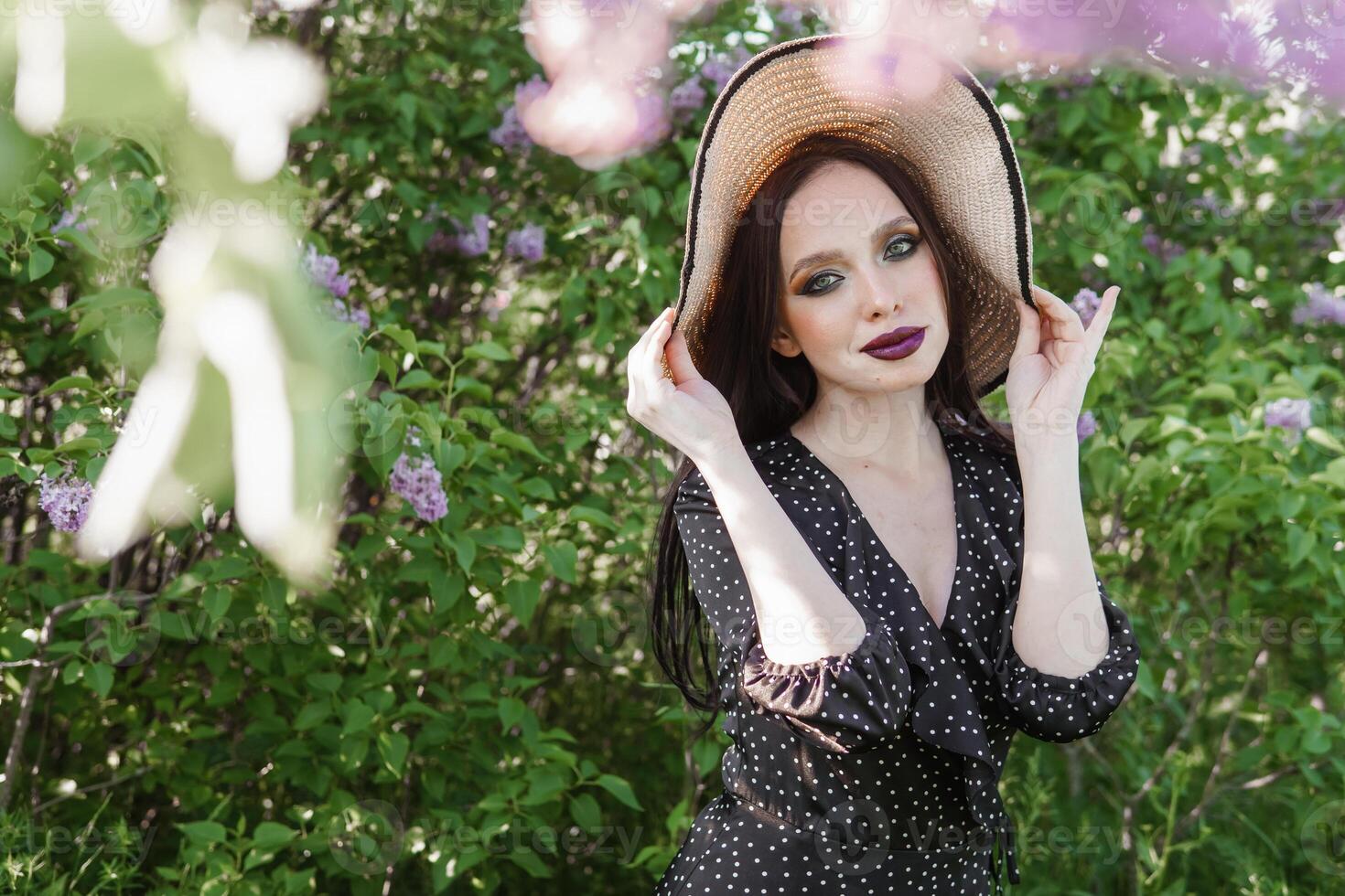 une à la mode fille avec foncé cheveux, une printemps portrait dans lilas tons dans été. brillant professionnel se maquiller. photo