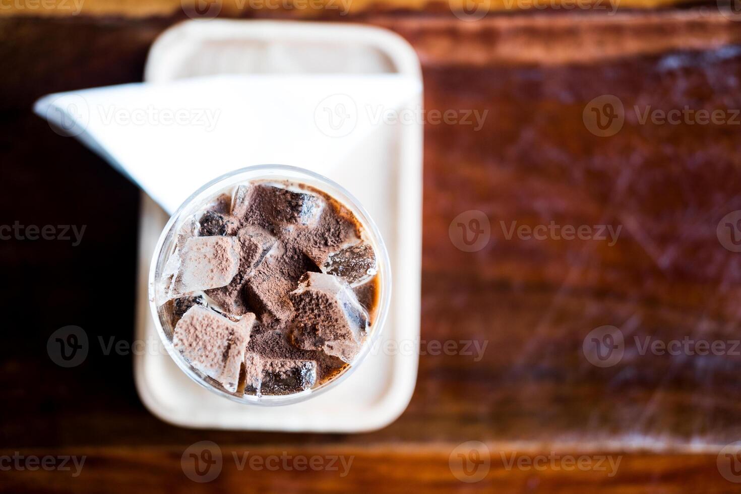 une verre de la glace moka café avec Garniture cette saupoudrer Chocolat poudre plus de le surface dans bois table photo