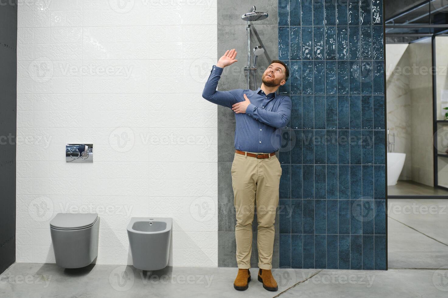 sélectionne une douche robinet. homme choisit une des produits dans une sanitaire vaisselle boutique photo