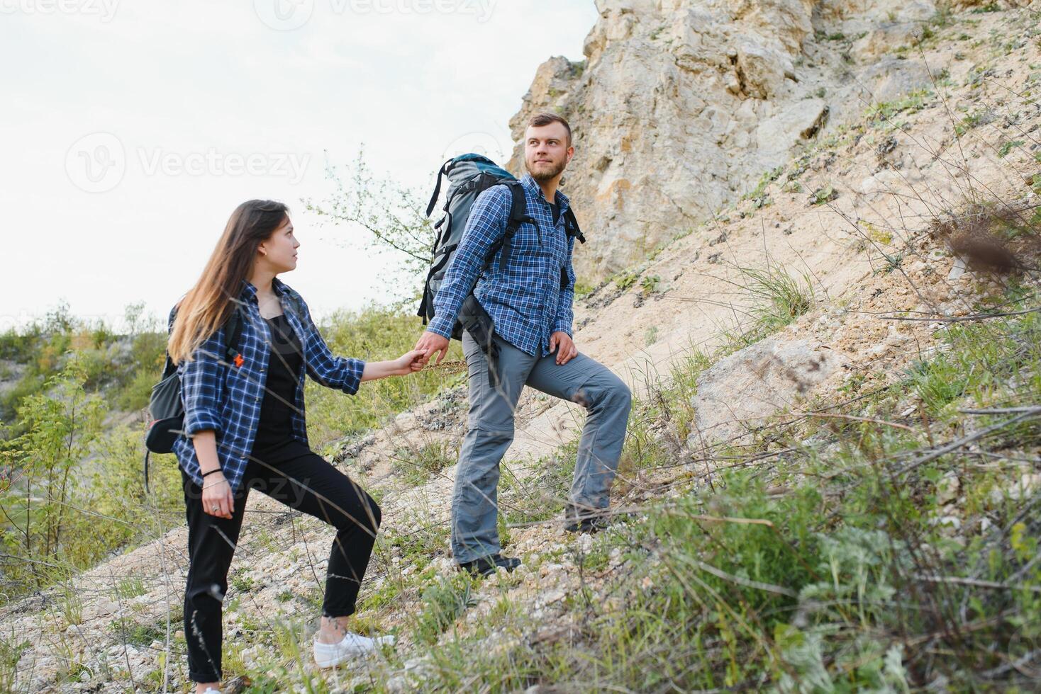 promeneur gars donne une main à le fille tandis que en marchant dans le montagnes, Aidez-moi et relation amicale concept photo