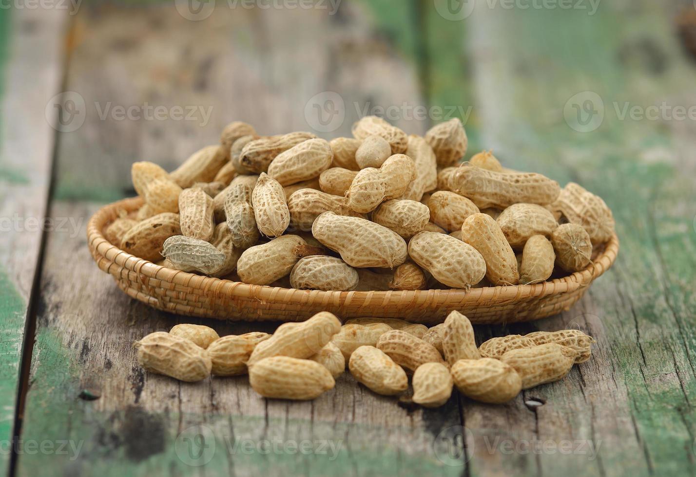 cacahuètes dans le panier sur bois photo