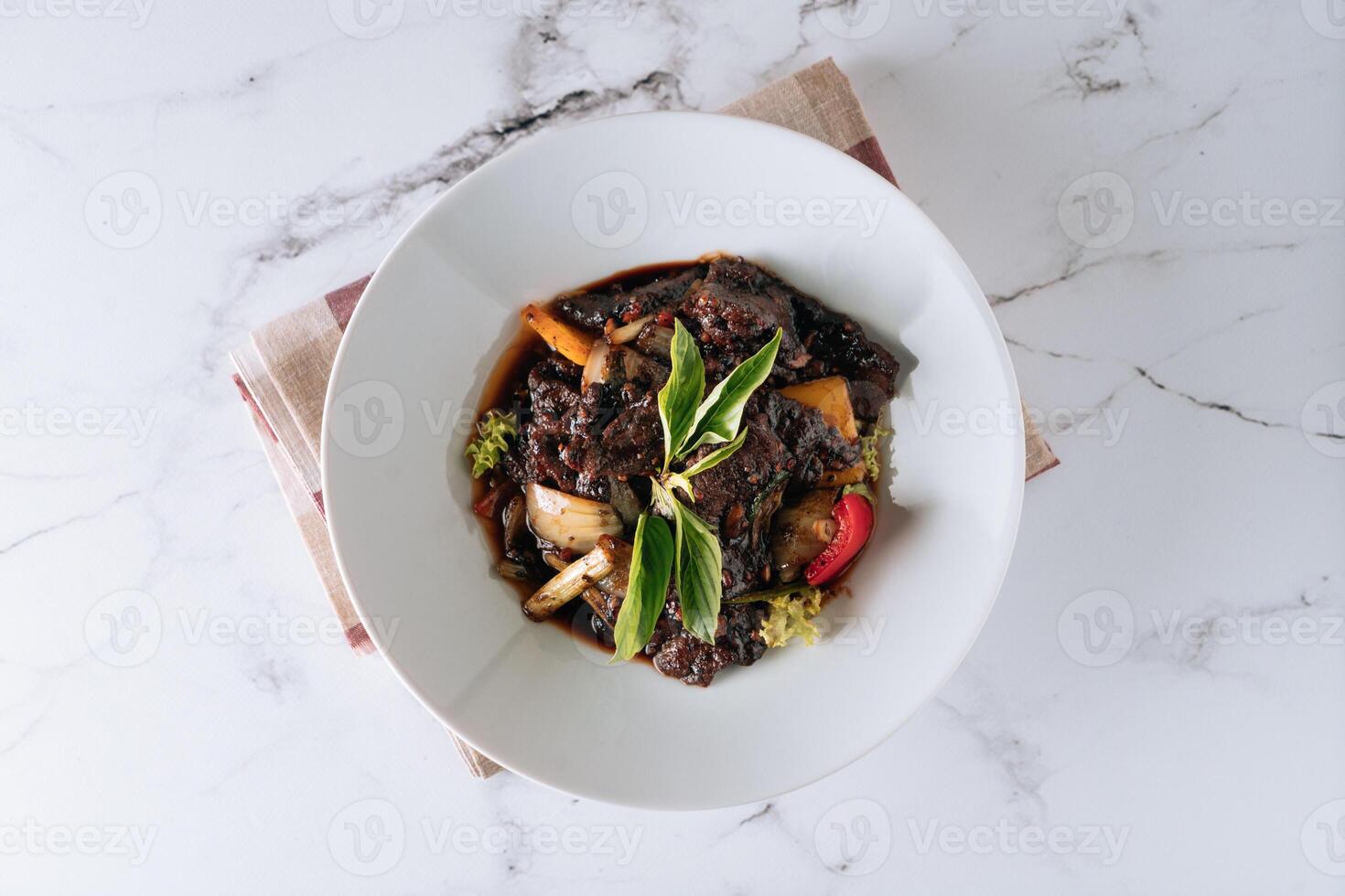 noir poivre du boeuf avec champignon, tomate, oignon dans une plat isolé sur tapis Haut vue sur gris marbre Contexte photo