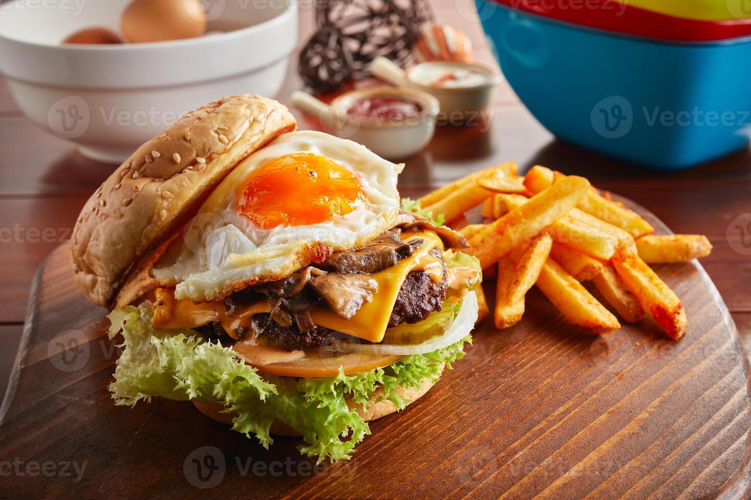 champignon Suisse du boeuf Burger avec ensoleillé Oeuf et frites servi dans une plat isolé sur en bois Contexte côté vue photo
