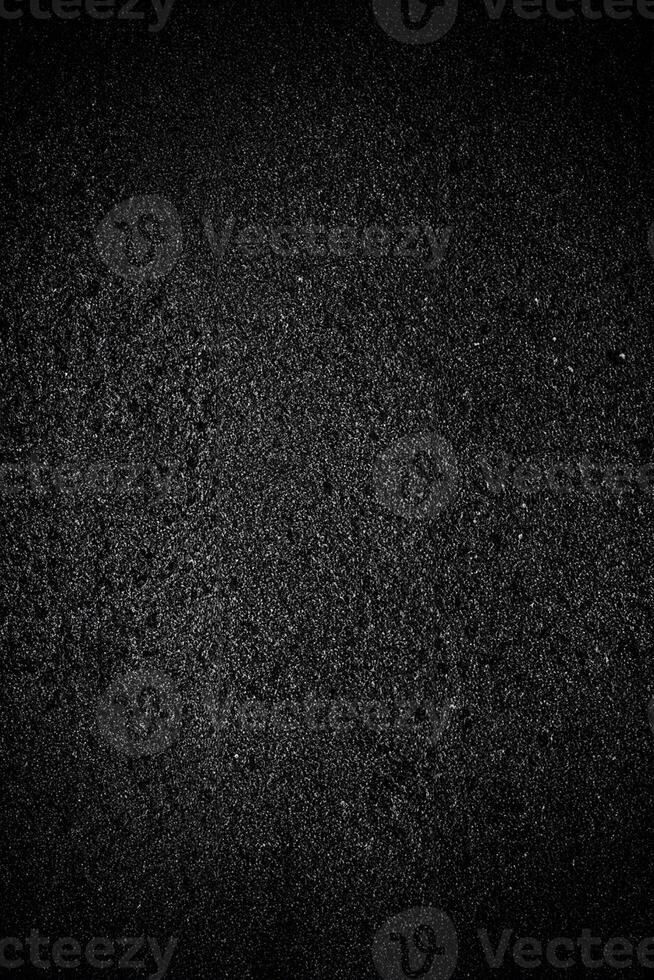 abstrait noir granuleux texture recouvrir sur asphalte Contexte. photo
