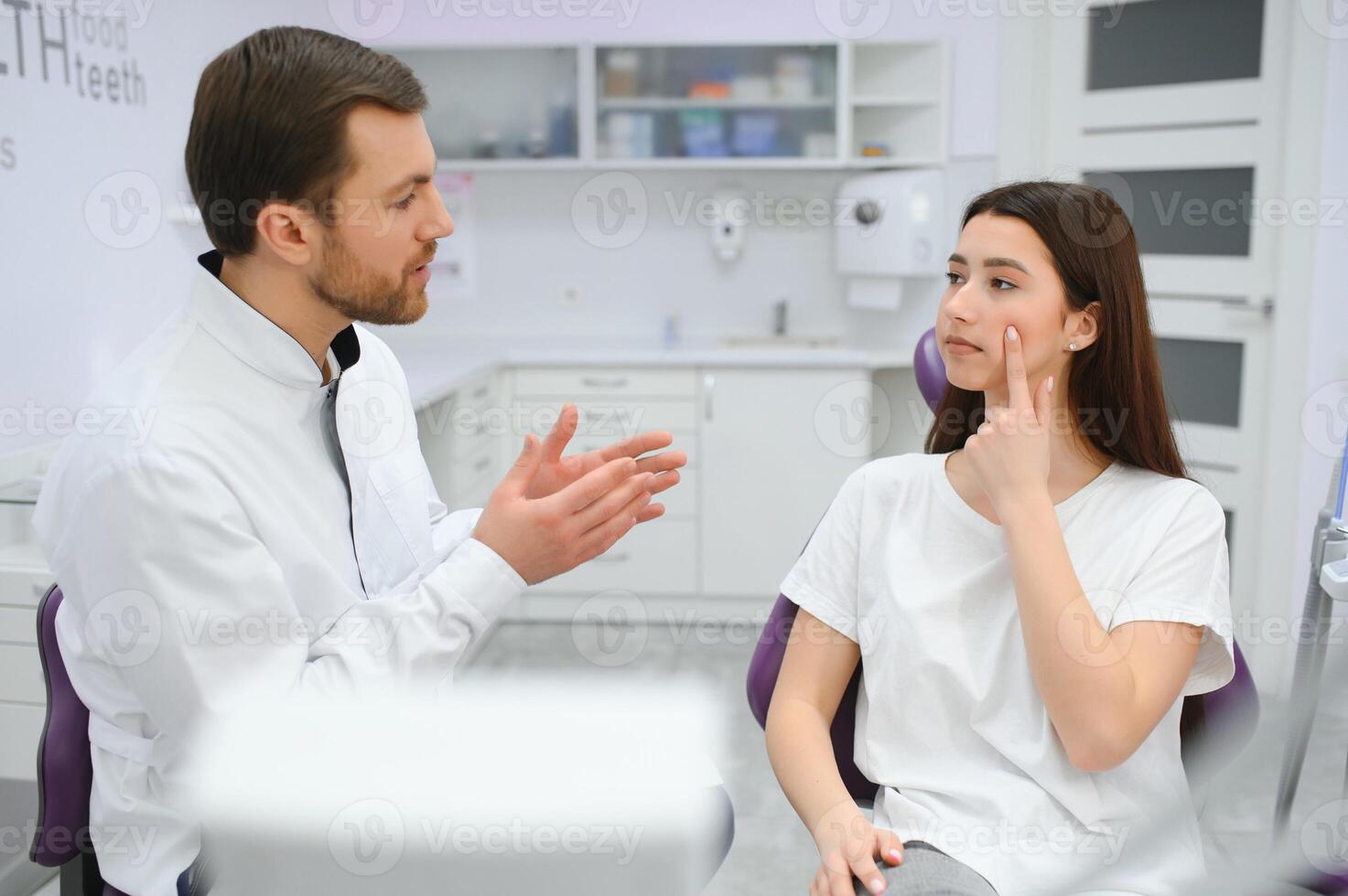 image de jolie Jeune femme séance dans dentaire chaise à médical centre tandis que professionnel médecin fixation sa les dents photo