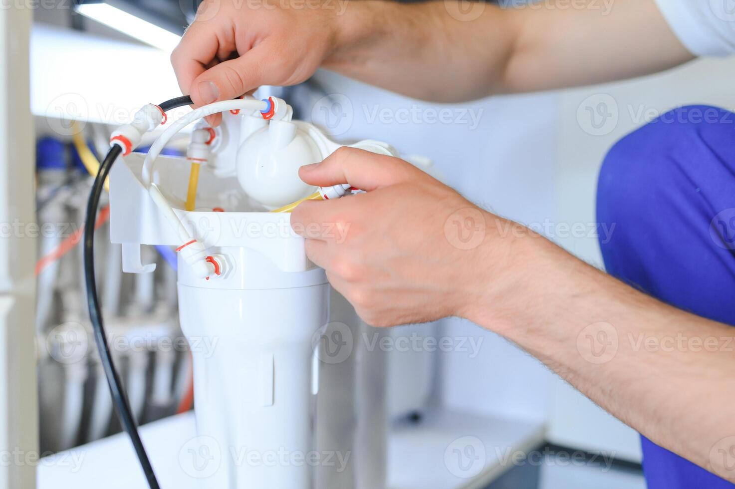 plombier installe ou changement l'eau filtre. remplacement aqua filtre. dépanneur installation l'eau filtre cartouches dans une cuisine. installation de sens inverse osmose l'eau purification système. photo