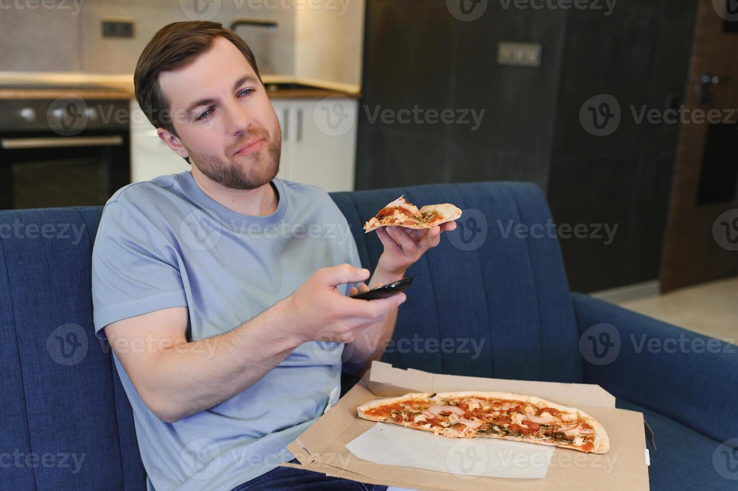 homme en mangeant Pizza ayant une à emporter à Accueil relaxant repos photo
