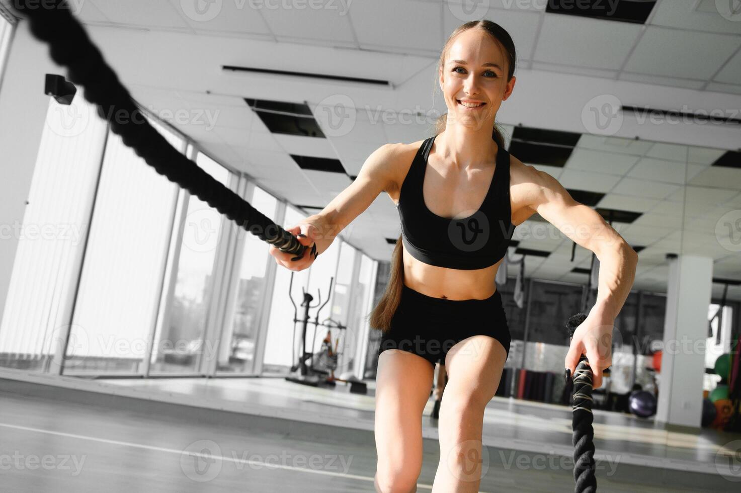 une fille est Faire des exercices en utilisant des sports équipement - une corde, en jouant des sports dans le salle de sport. photo