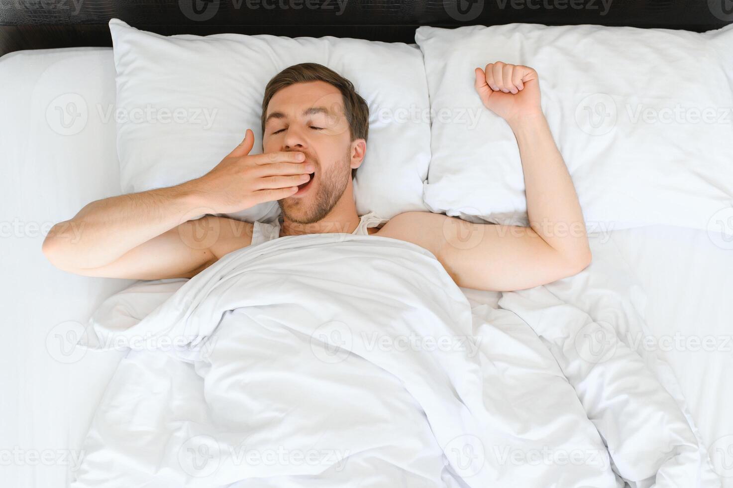 mignonne Jeune homme en train de dormir sur lit photo