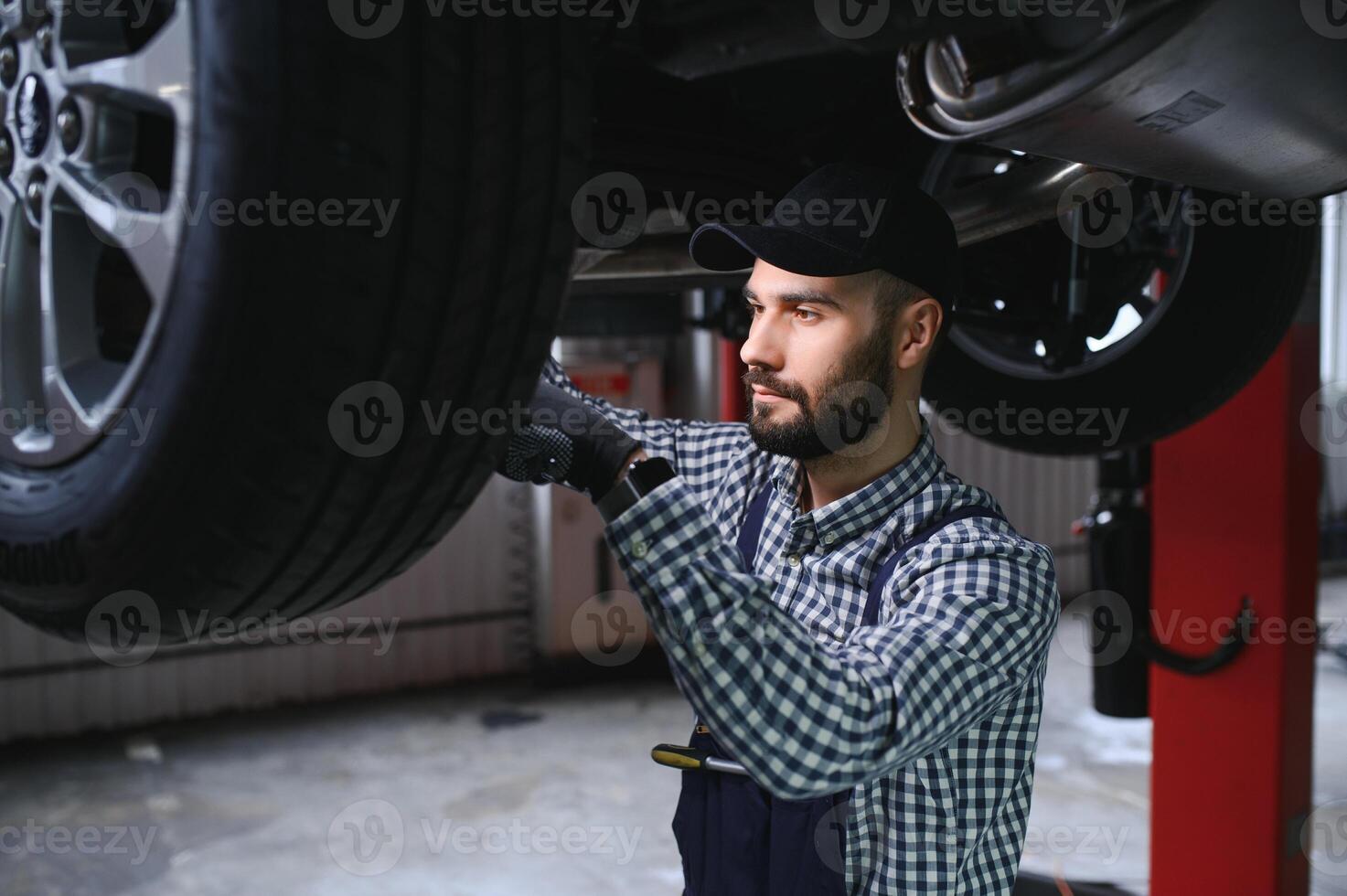 auto mécanicien travail sous une levé voiture photo