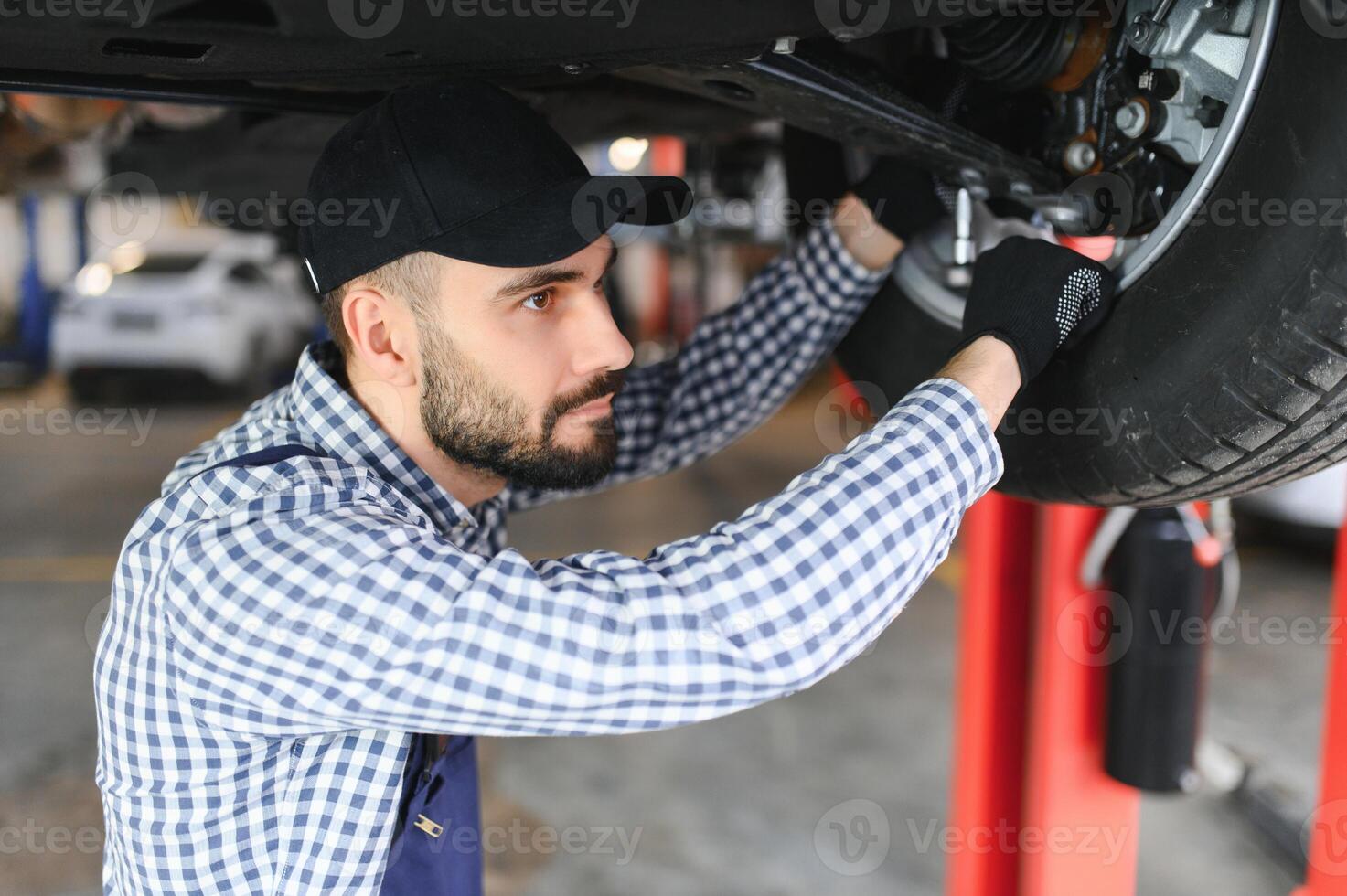 adulte homme dans bleu coloré uniforme travaux dans le voiture salon. photo