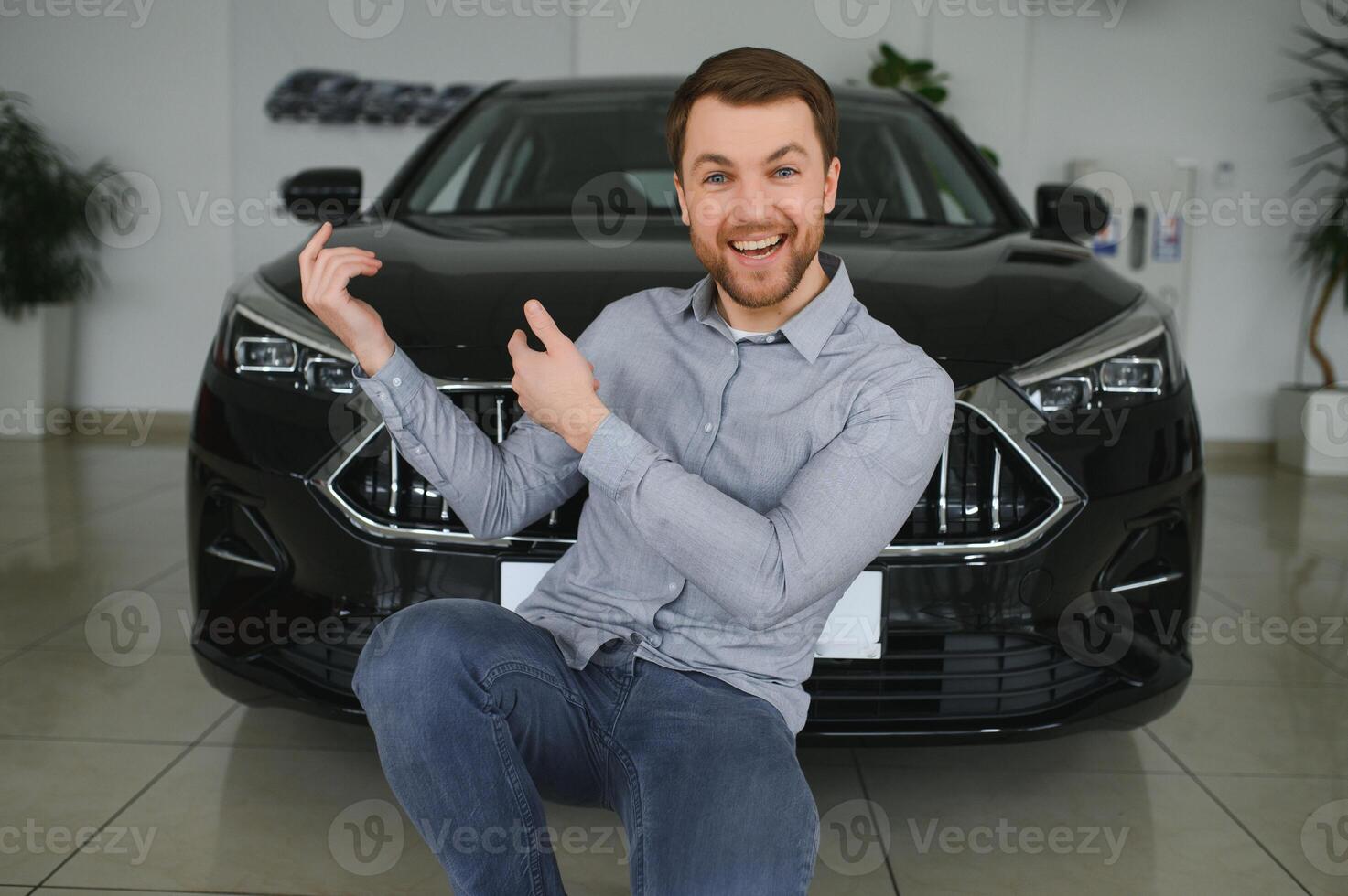 visite voiture concession. Beau barbu homme est caressant le sien Nouveau voiture et souriant. photo