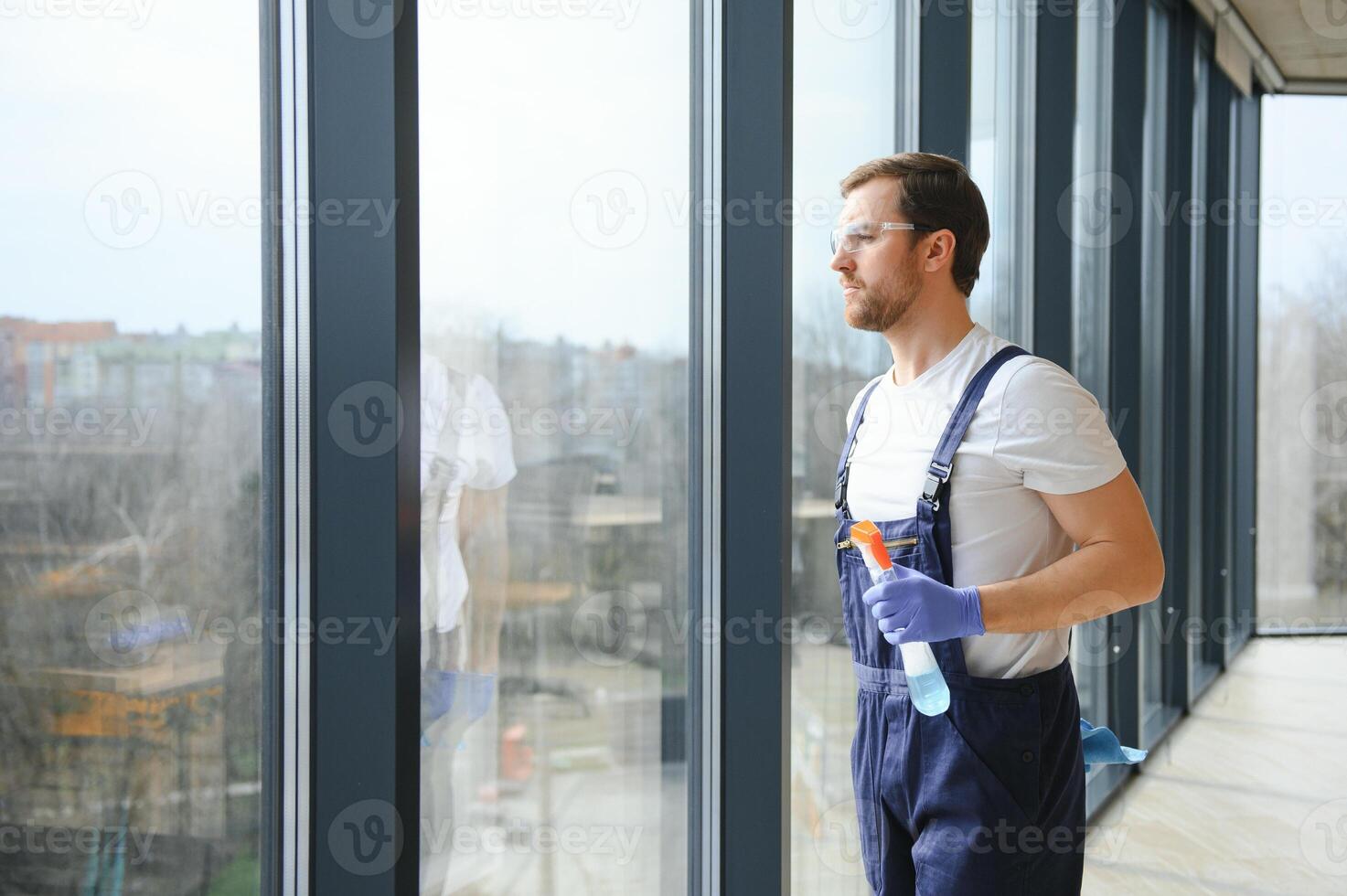 un employé de une professionnel nettoyage un service lavages le verre de le les fenêtres de le bâtiment. vitrine nettoyage pour magasins et entreprises. photo