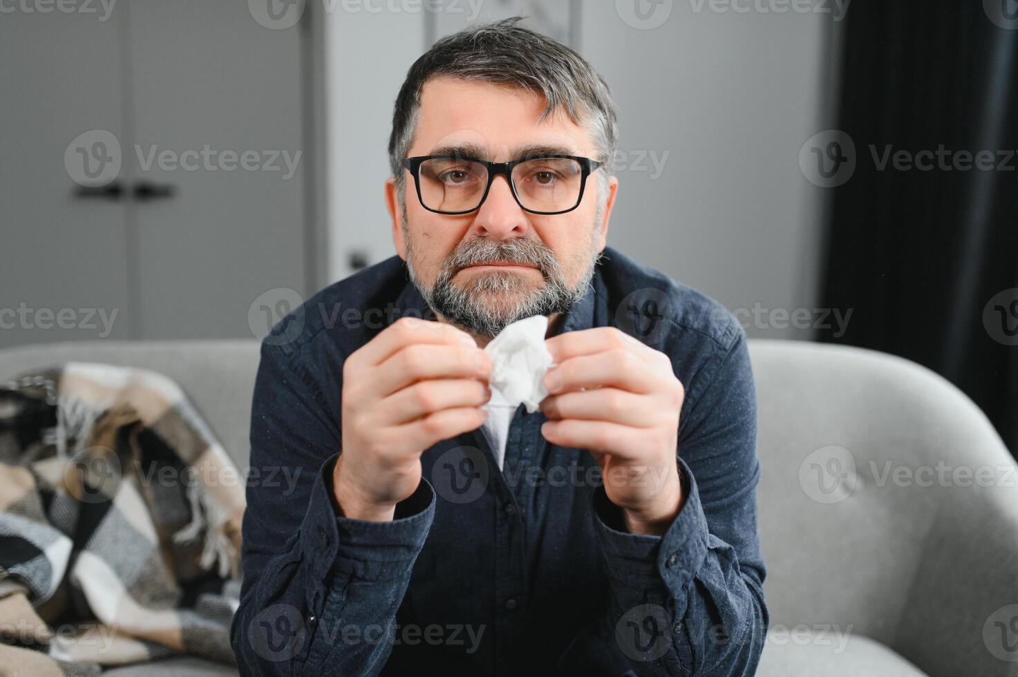 milieu âge homme sentiment malade avec du froid et fièvre à maison, mauvais avec grippe maladie séance sur le canapé photo