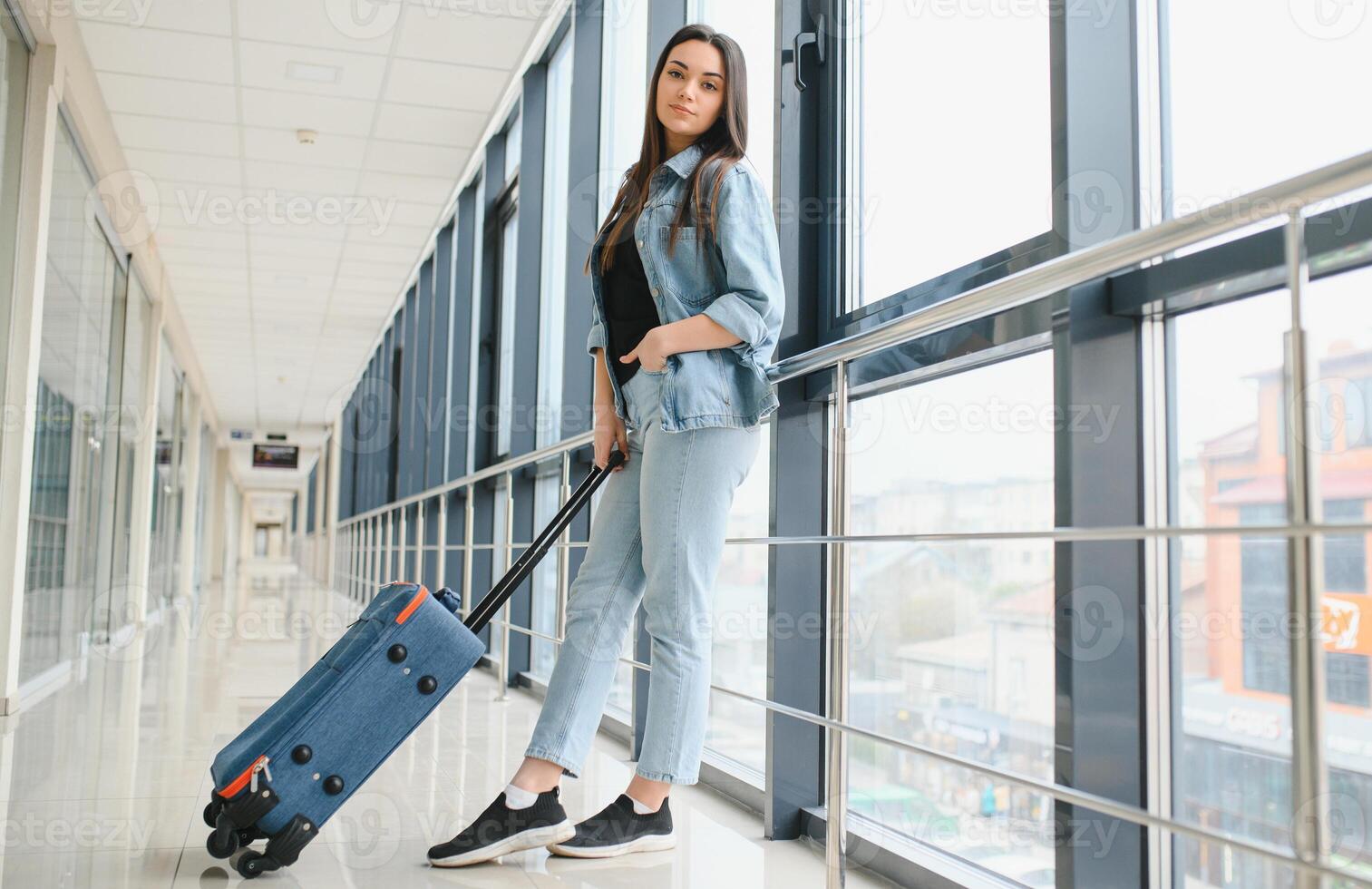 Jeune femme tirant valise dans aéroport Terminal. copie espace photo